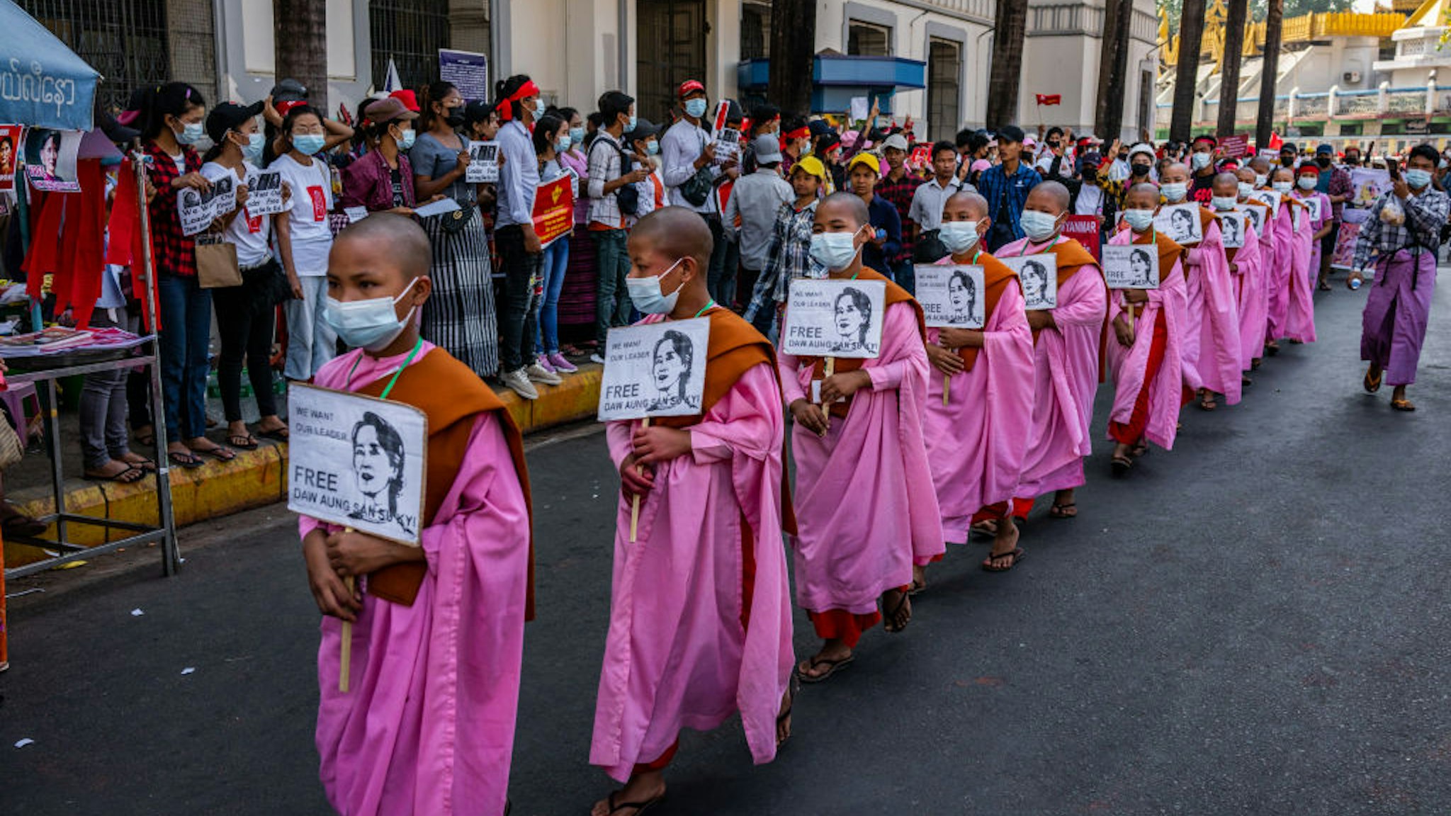 YANGON, MYANMAR - FEBRUARY 13: Buddhist monks hold placards featuring images of Aung San Suu Kyi during a protest on February 13, 2021 in Yangon, Myanmar. Myanmar declared martial law in parts of the country, including its two largest cities, as protests continued to draw people to the streets after the country's military junta staged a coup against the elected National League For Democracy (NLD) government and detained de-facto leader Aung San Suu Kyi. The U.S. government imposed sanctions and froze the U.S. assets of several of the coup's leaders and their families. (Photo by Hkun Lat/Getty Images)