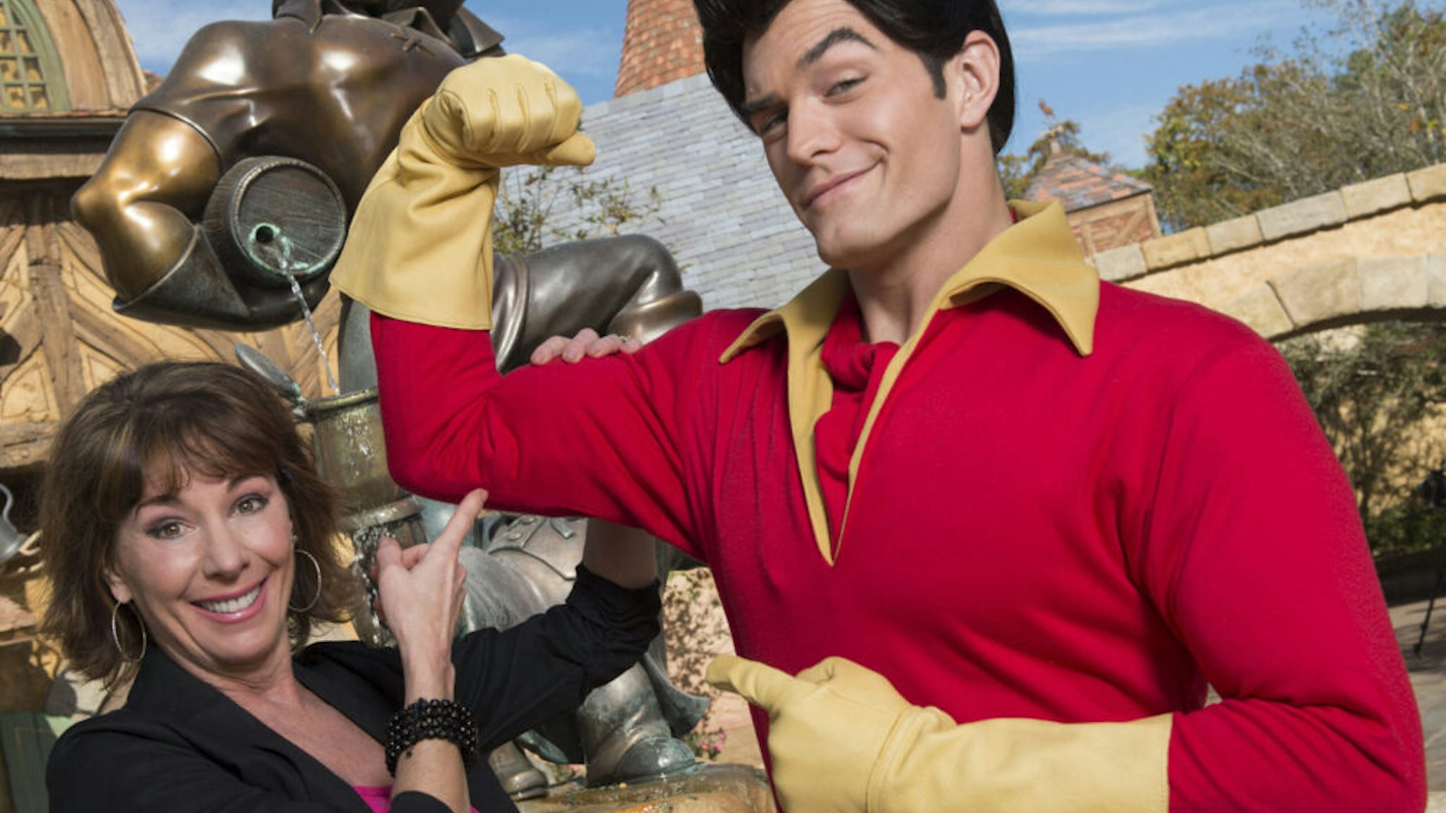LAKE BUENA VISTA, FL - DECEMBER 05: In this handout image provided by Disney Parks, Broadway and recording star Paige O'Hara poses with Disney's "Beauty and the Beast" character Gaston in New Fantasyland December 5, 2012 at the Magic Kingdom park at Walt Disney World in Lake Buena Vista, Florida. The new land, which holds its official Grand Opening tomorrow, features several settings and scenes from Disney's "Beauty and the Beast," including Gaston's Tavern. O'Hara, who was honored as a "Disney Legend" in 2011, provided the singing and speaking voice for Belle, the animated star of "Beauty and the Beast."