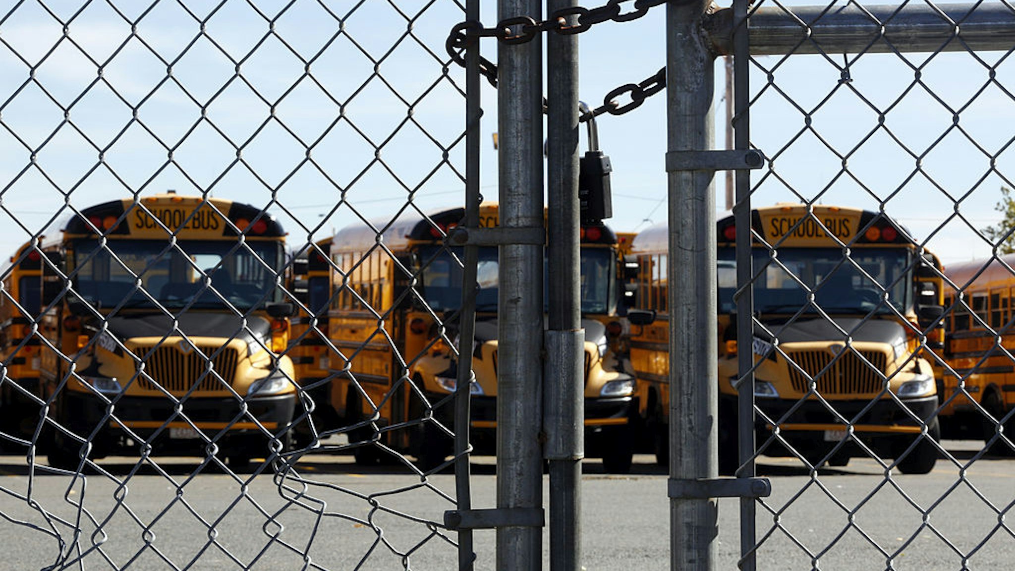 Buses are seen behind a padlocked gate after bus drivers were locked out of the yard in Dorchester, Mass., Oct. 8, 2013.