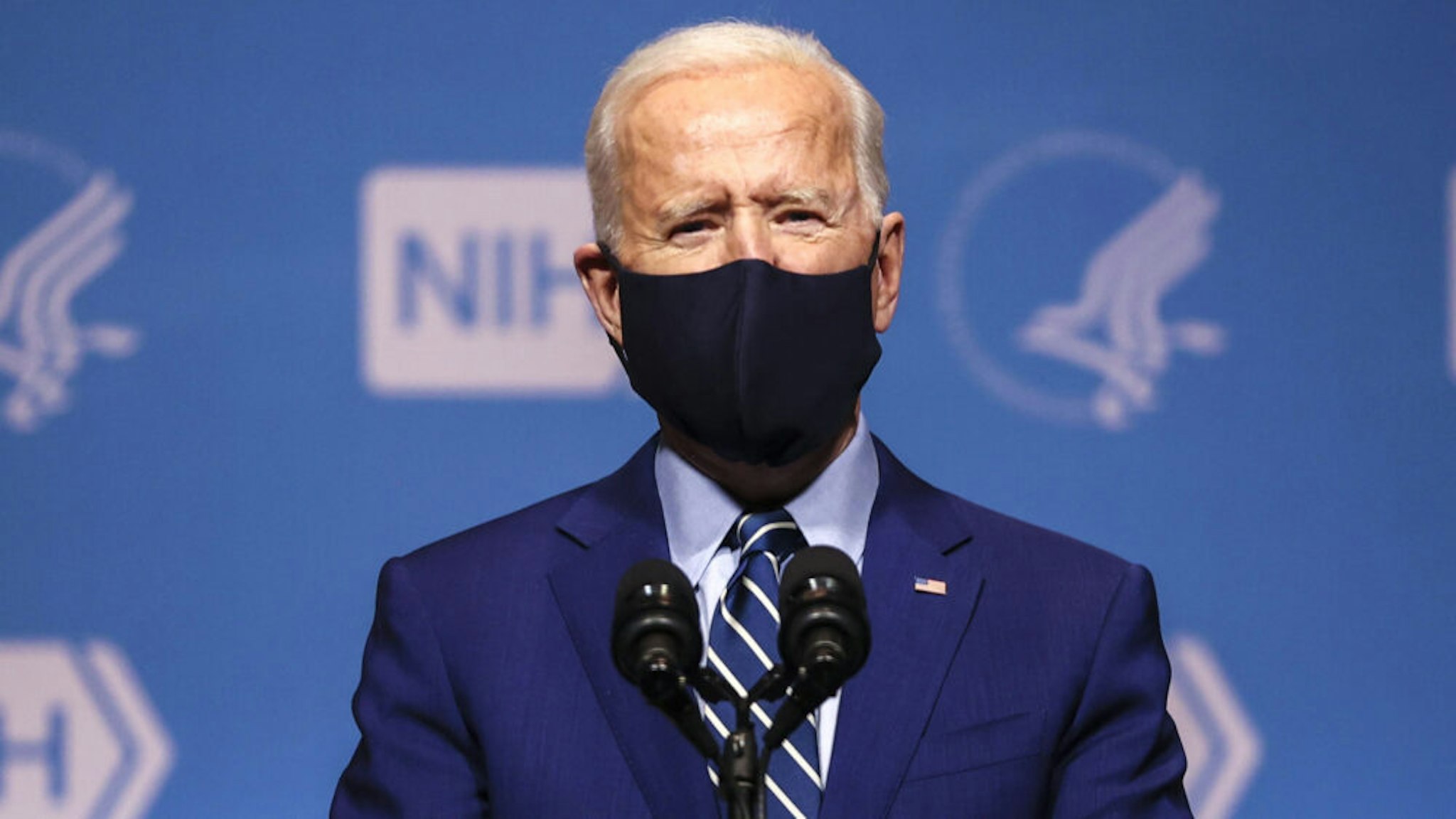 U.S. President Joe Biden wears a protective mask while speaking at the National Institutes of Health (NIH) in Bethesda, Maryland, U.S., on Thursday, Feb. 11, 2021. Biden announced the U.S. Department of Health and Human Services (HHS) and Department of Defense (DOD) have purchased an additional 100 million doses of Covid-19 vaccines from both Pfizer Inc. and Moderna Inc.