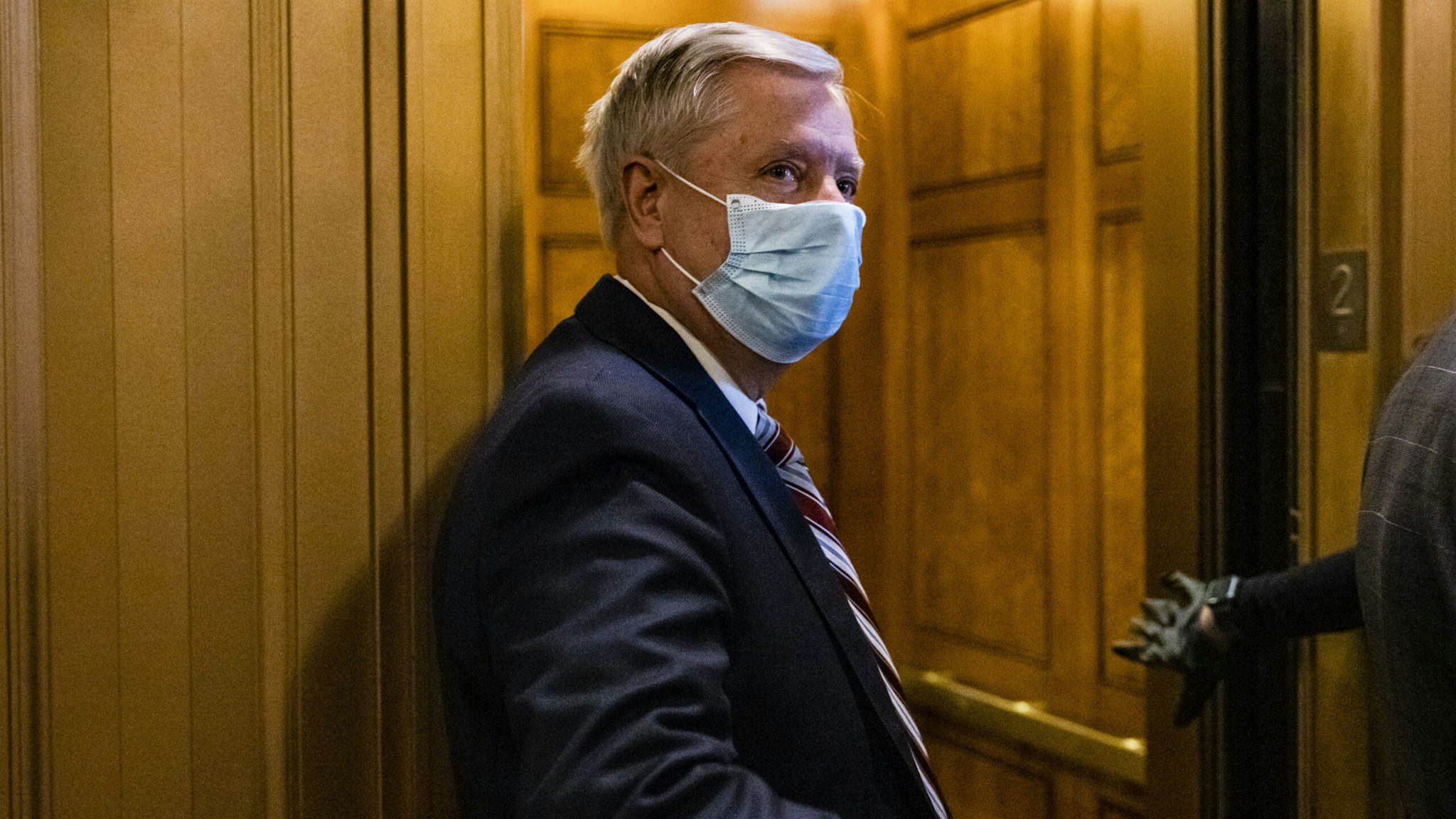WASHINGTON, DC - JANUARY 26: Sen. Lindsey Graham (R-SC) leaves the floor of the Senate following a vote on January 26, 2021 in Washington, DC. Today senators will be sworn in as the jury for the second impeachment trial of former President Donald Trump. Senate President pro tempore Patrick Leahy (D-VT) will preside over the trial in place of Supreme Court Chief Justice John Roberts.