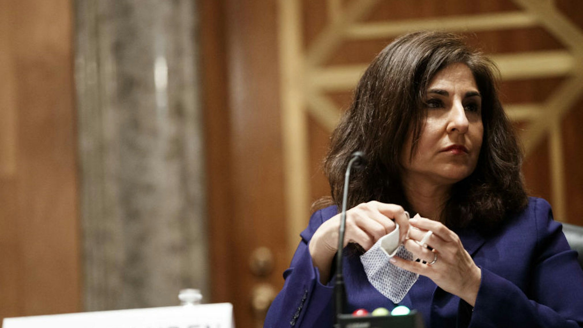 Neera Tanden, director of the Office and Management and Budget (OMB) nominee for U.S. President Joe Biden, removes her mask during a Senate Homeland Security and Governmental Affairs Committee confirmation hearing in Washington, D.C., U.S., on Tuesday, Feb. 9, 2021. Tanden, who pledged to work with both parties after drawing sharp criticism from Republicans for sniping at them on social media, worked on the Affordable Care Act during the Obama years and was an aide to Hillary Clinton from her time as first lady.
