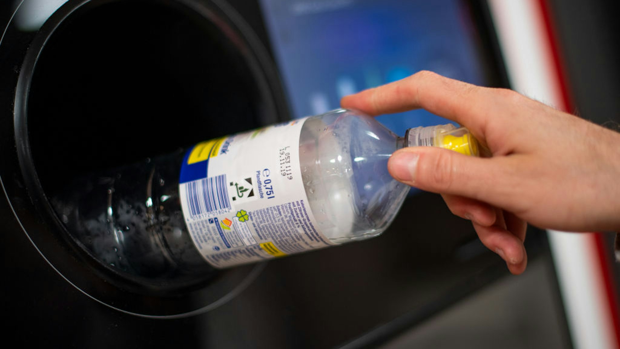 A man puts a deposit bottle into a deposit bottle machine in a supermarket. Photo: Monika Skolimowska/dpa-Zentralbild/ZB