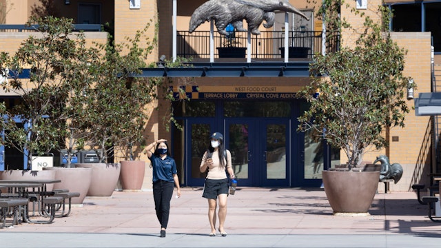 Two women walk through a mostly empty campus at the University of California, Irvine in Irvine, CA on Friday, October 2, 2020. Classes started Thursday, October 1st but most are online, leaving few students on campus. "nStudent housing was at 43% capacity, or about 6,600 students, and most classes were online due to COVID-19 restrictions. Fall quarter is almost entirely online with a few undergraduate classes in-person.