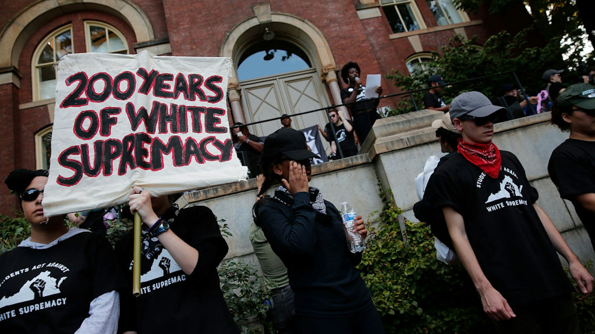 Protesters with the group Students Act Against White Supremacy speak on the campus of the University of Virginia during an event marking the one year anniversary of a deadly clash between white supremacists and counter protesters August 11, 2018 in Charlottesville, Virginia. Charlottesville has been declared in a state of emergency by Virginia Gov. Ralph Northam as the city braces for the one year anniversary of the deadly clash between white supremacist forces and counter protesters over the potential removal of Confederate statues of Robert E. Lee and Stonewall Jackson. A ÒUnite the RightÓ rally featuring some of the same groups is planned for tomorrow in Washington, DC.