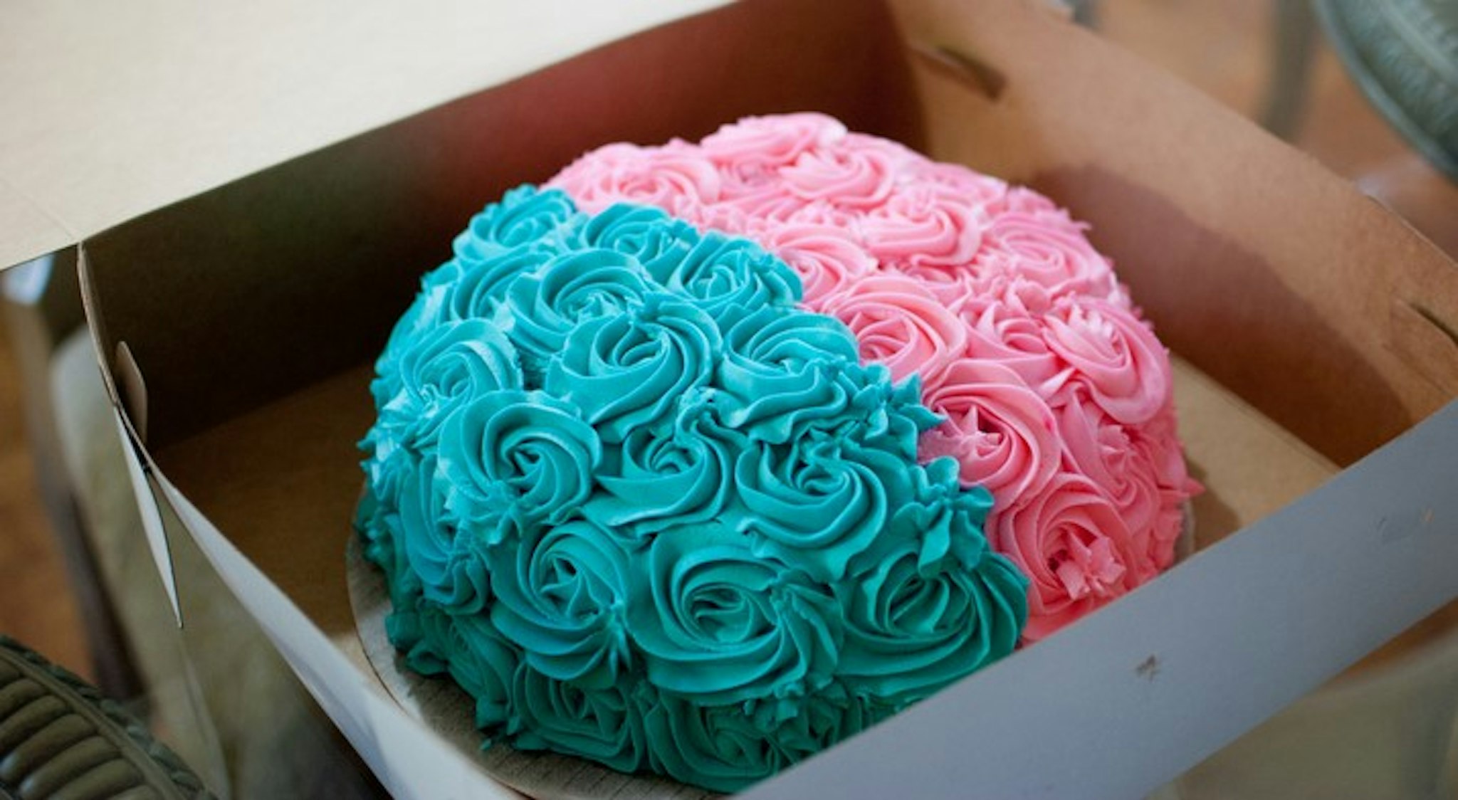 A pink and blue cake used at a gender reveal baby shower.