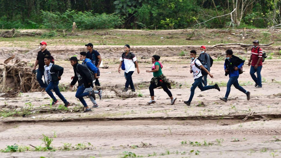 HONDURAS-US-MIGRATION-CARAVAN Migrants heading to the border with Guatemala on their way to the United States, cross the dried riverbed of the Copan River in the municipality of Santa Rita, in the Honduran department of Copan, on January 15, 2021. - Hundreds of asylum seekers are forming new migrant caravans in Honduras, planning to walk thousands of kilometers through Central America to the United States via Guatemala and Mexico, in search of a better life under the new administration of President-elect Joe Biden.