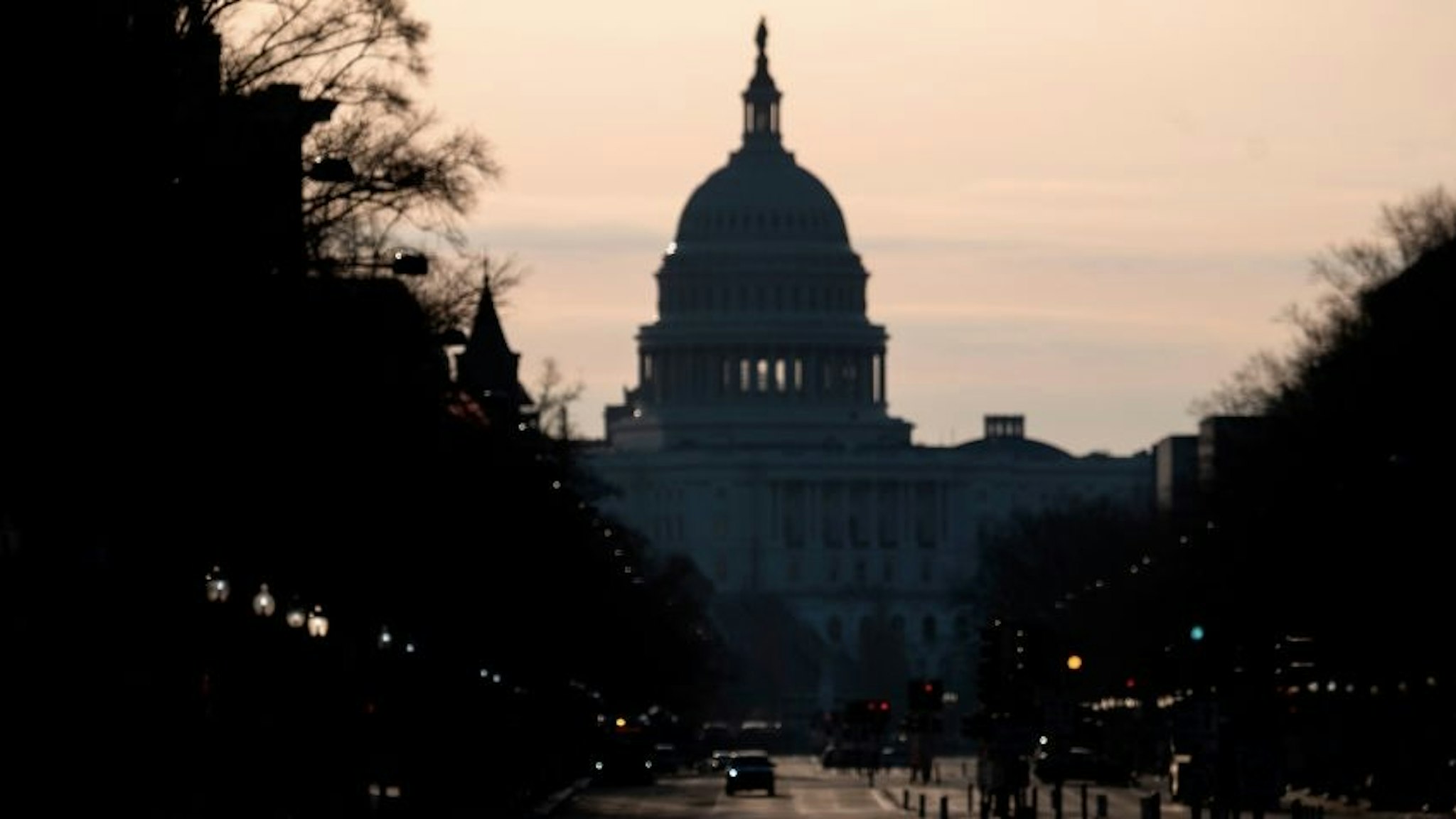A woman walks on a empty street near the US Capitol as the sun rises in Washington, DC, on March 4, 2021. - Lawmakers and staff were advised to stay away from the US Capitol after the FBI and Homeland Security Department warned that violent militia groups and QAnon followers had discussed attacking the legislature on or about March 4. The FBI-Homeland Security bulletin said extremists are still motivated by unfounded Republican claims of widespread voter fraud in the November presidential election won by Democrat Joe Biden. (Photo by ANDREW CABALLERO-REYNOLDS / AFP) (Photo by ANDREW CABALLERO-REYNOLDS/AFP via Getty Images)