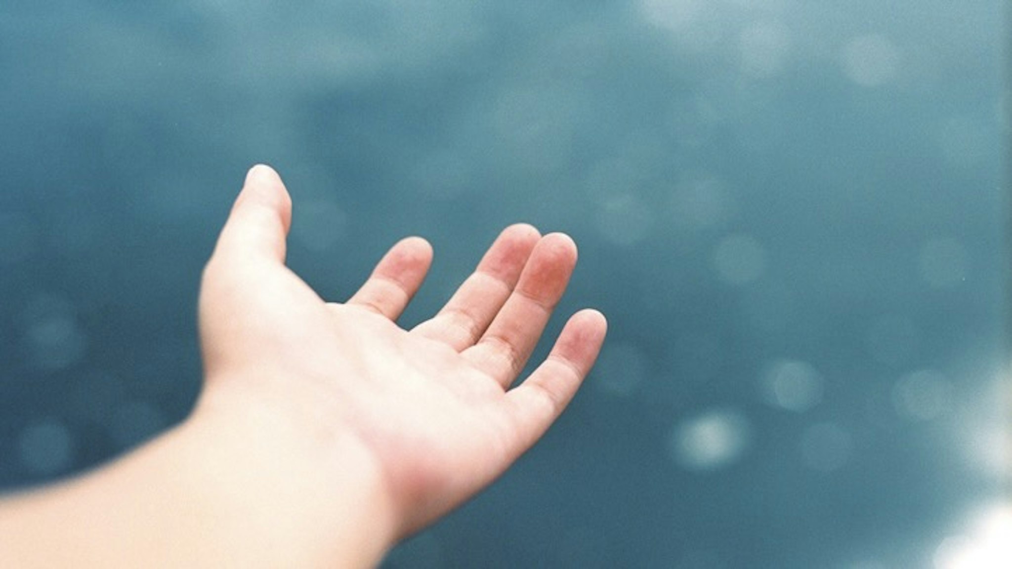Cropped Image Of Hand Against Sea - stock photo