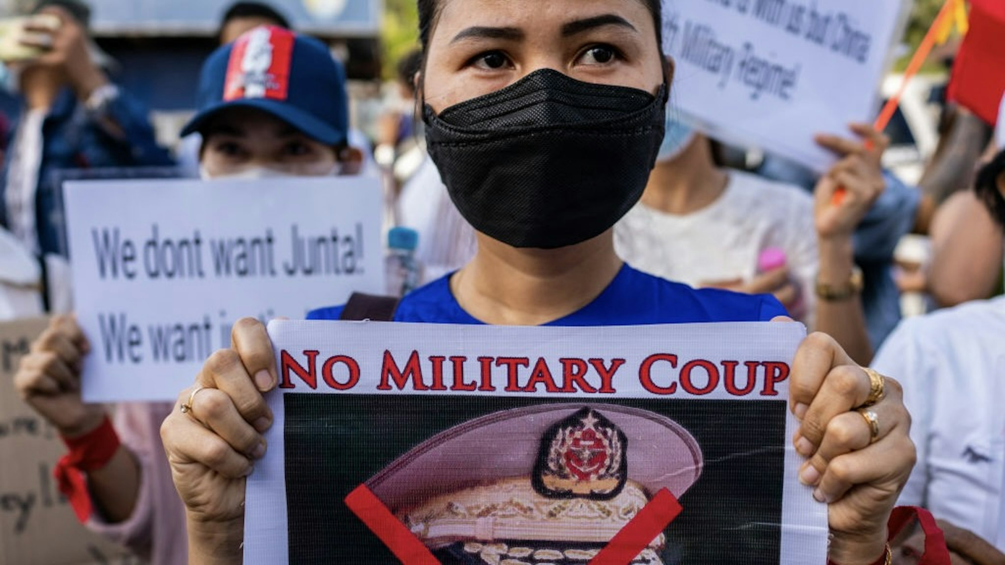YANGON, MYANMAR - FEBRUARY 12: Protesters hold banners against the military coup and in favor of democracy outside the Russian embassy on February 12, 2021 in Yangon, Myanmar. Myanmar declared martial law in parts of the country, including its two largest cities, as protests continued to draw people to the streets after the country's military junta staged a coup against the elected National League For Democracy (NLD) government and detained de-facto leader Aung San Suu Kyi. The U.S. government imposed sanctions and froze the U.S. assets of several of the coup's leaders and their families. (Photo by Hkun Lat/Getty Images)
