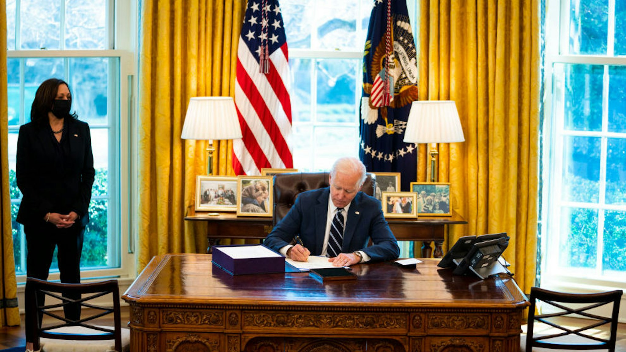 President Joe Biden signs the American Rescue Plan with Vice President Kamala Harris looking on in the Oval Office, Thursday, March, 11, 2021.