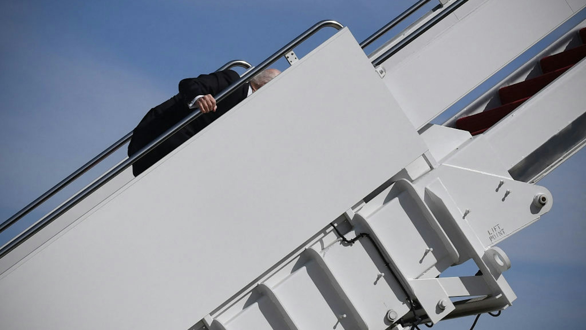 US President Joe Biden trips while boarding Air Force One at Joint Base Andrews in Maryland on March 19, 2021. - President Biden travels to Atlanta, Georgia, to tour the Centers for Disease Control and Prevention, and to meet with Georgia Asian American leaders, following the Atlanta Spa shootings.