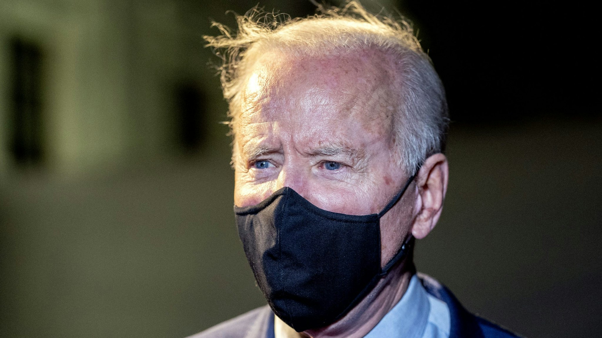 U.S. President Joe Biden wears a protective mask while speaking to members of the media on the South Lawn of the White House after arriving on Marine One in Washington, D.C., U.S., on Tuesday, March 23, 2021. Biden traveled to Ohio to promote his $1.9 trillion stimulus, as Democrats take aim at a Senate seat that will be open in next year's midterm elections.