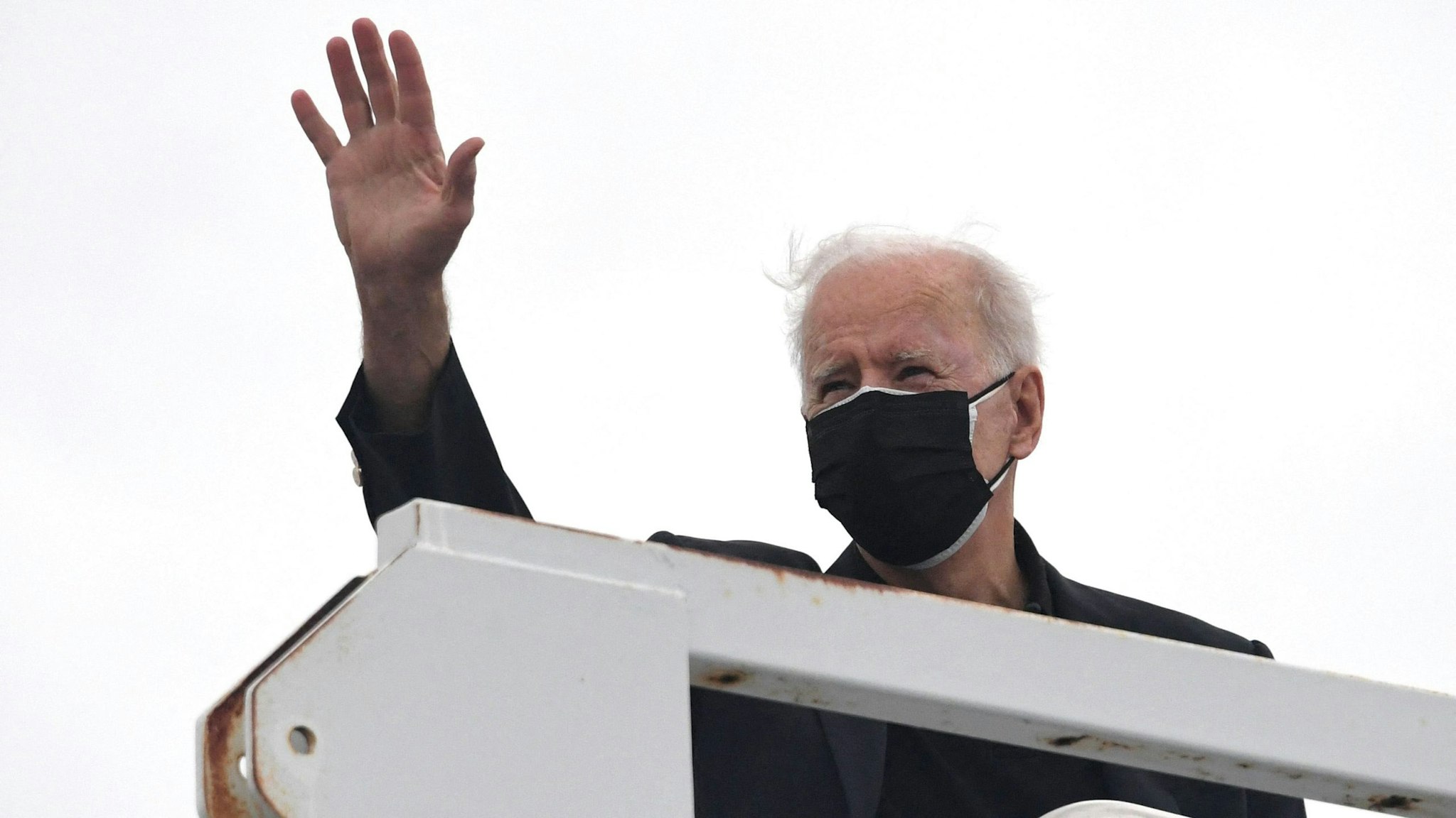 US President Joe Biden waves before boarding Air Force One after spending the weekend in Wilmington, at New Castle airport in New Castle, Delaware on March 28, 2021.
