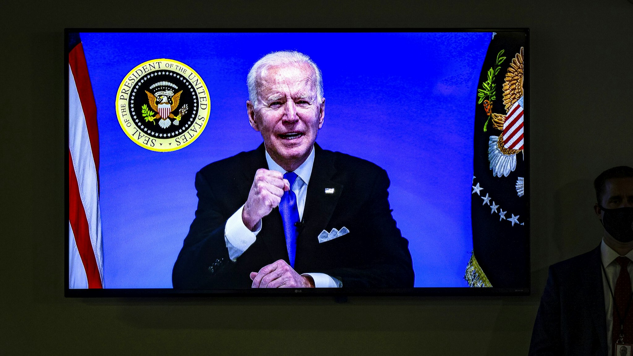 WASHINGTON, DC - MARCH 03: A screen in the auditorium shows President Joe Biden as he participates in a virtual event with members of the House Democratic Caucus from the South Court Auditorium in the Eisenhower Executive Office Building next to the White House on March 3, 2021 in Washington, DC.