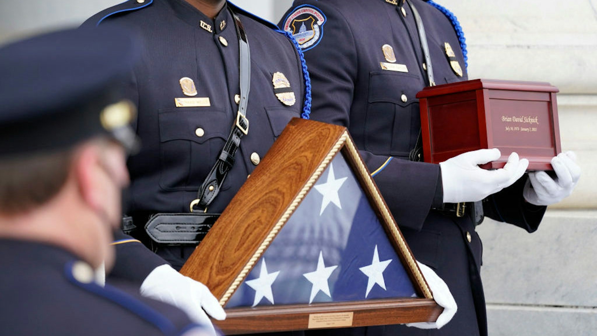 An honor guard carries an urn with the cremated remains of U.S. Capitol Police officer Brian Sicknick down the steps of the U.S Capitol, Wednesday, Feb. 3, 2021, in Washington. (AP Photo/Alex Brandon, Pool)