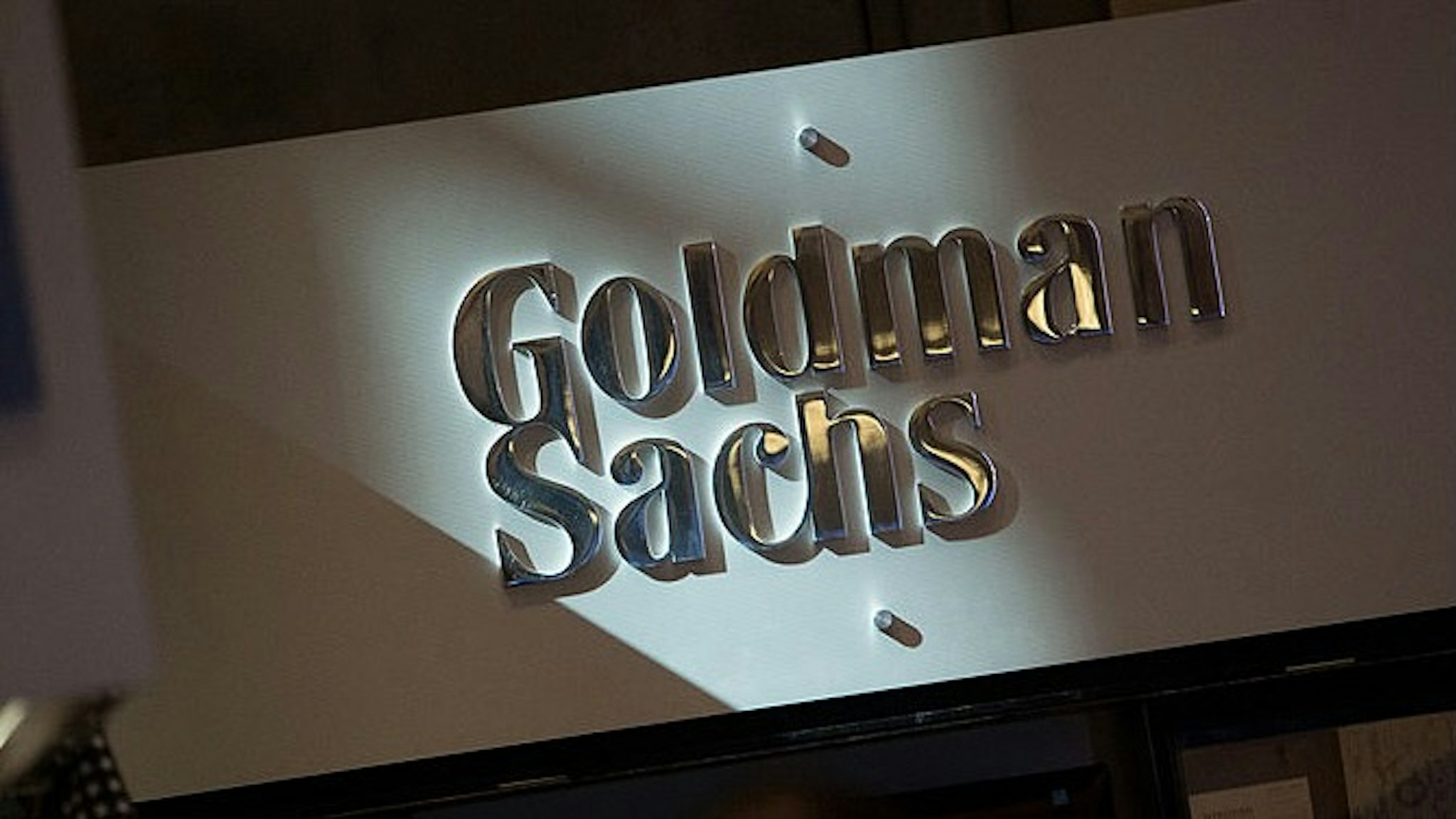 The Goldman Sachs &amp; Co. logo is displayed at the company's booth on the floor of the New York Stock Exchange (NYSE) in New York, U.S., on Friday, July 19, 2013. U.S. stocks fell after benchmark equities gauges rose to records yesterday, after disappointing earnings from Google Inc. and Microsoft Corp. overshadowed better-than-forecast results from General Electric Co. Photographer: Scott Eells/Bloomberg via Getty Images