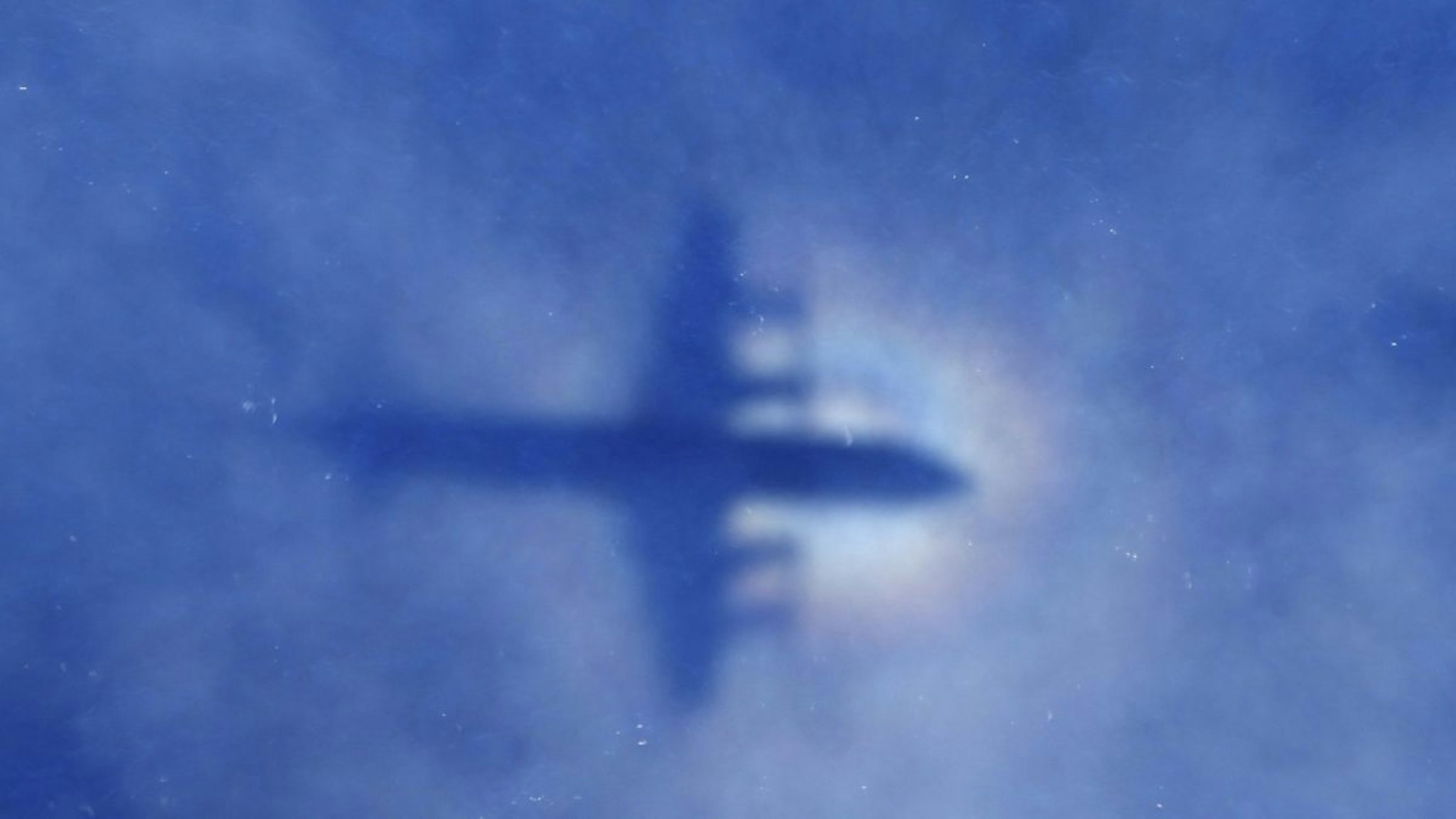 This shadow of a Royal New Zealand Air Force P3 Orion aircraft is seen on low cloud cover while it searches for missing Malaysia Airlines flight MH370, over the Indian Ocean on March 31, 2014.
