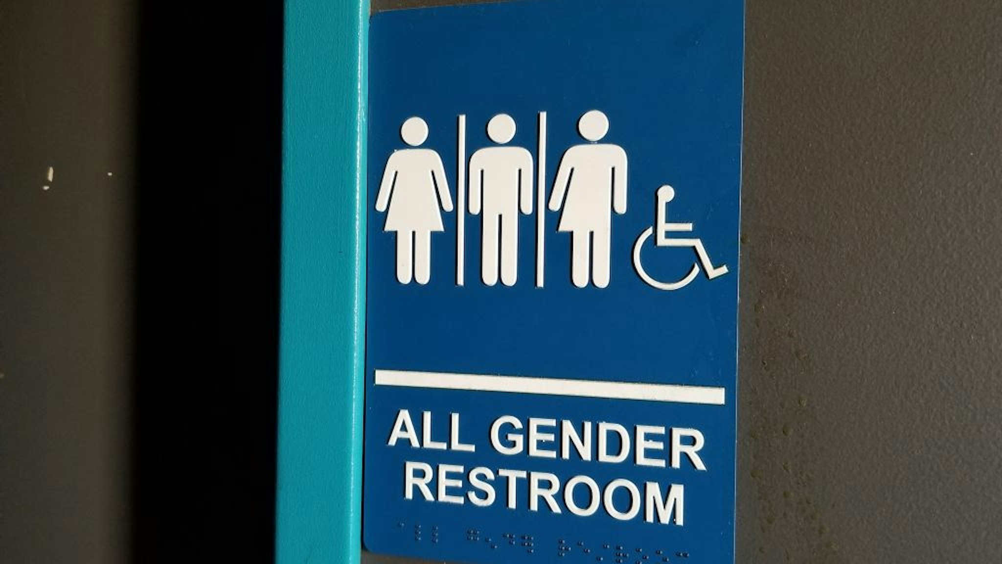 Close-up of sign for all gender restroom in Dublin, California, with male, female and gender-inclusive stick figure illustrations, March 13, 2019.
