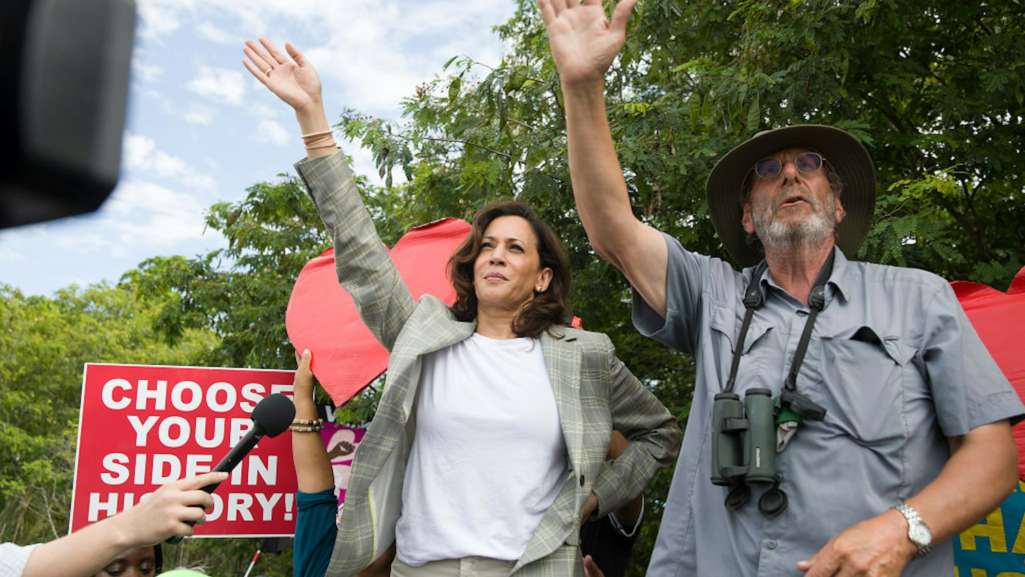 HOMESTEAD, FLORIDA - JUNE 28: Democratic Presidential candidate, Sen. Kamala Harris (D-CA) waves to children as she stands on a ladder to see over a fence into the grounds of a detention center for migrant children on June 28, 2019 in Homestead, Florida. Democratic presidential candidates visited the detention center, which is the nation's largest center for detaining immigrant children, as the candidates spend time in the Miami area after participating in a nationally televised debate. (Photo by Joe Raedle/Getty Images)