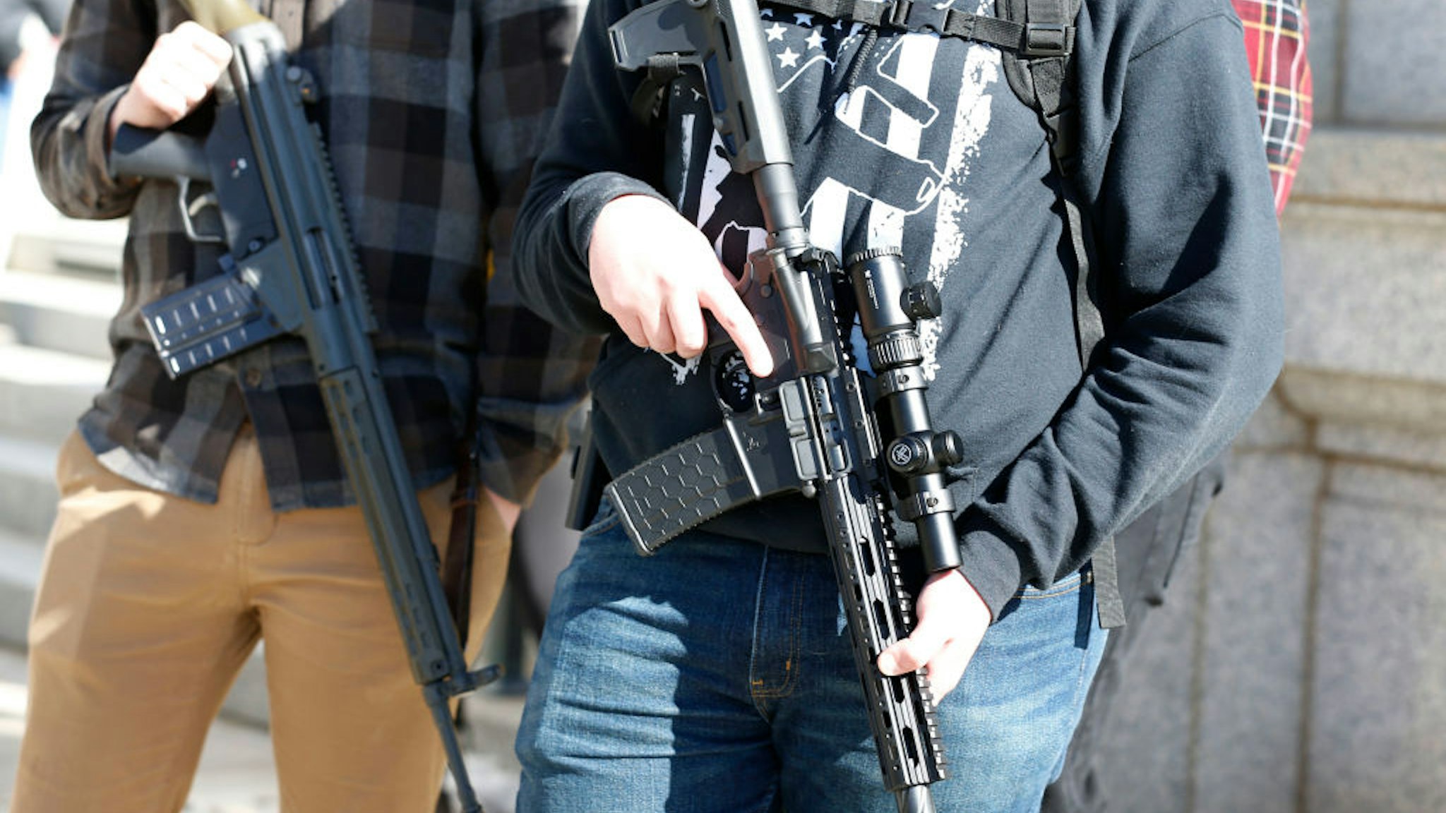 Two men with their firearms listen to speakers at a protest to new gun legislation at the Utah State Capitol in Salt Lake City, Utah on February 8, 2020. - The protestors are opposing new gun legislation that they say will restrict their US second amendment rights. Utah is an open carry state.