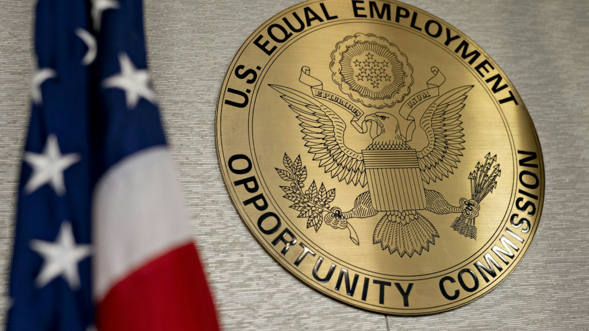 The Equal Employment Opportunity Commission (EEOC) seal hangs inside a hearing room at the headquarters in Washington, D.C., U.S., on Tuesday, Feb. 18, 2020. The Trump administration wants to cut fiscal year 2021 spending on the Labor Department, National Labor Relations Board, and EEOC, reviving previous belt-tightening bids that have not been approved by Congress.