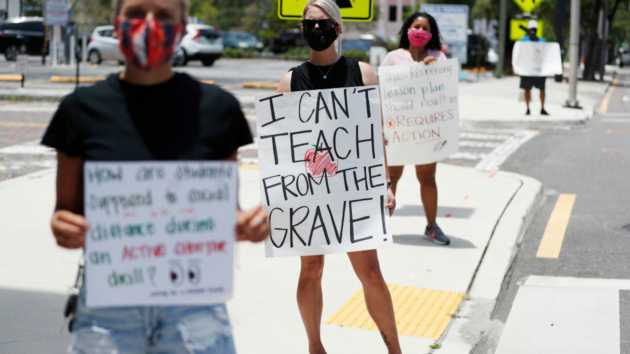 TAMPA, FL - JULY 16: Middle school teacher Brittany Myers, (C) stands in protest in front of the Hillsborough County Schools District Office on July 16, 2020 in Tampa, Florida. Teachers and administrators from Hillsborough County Schools rallied against the reopening of schools due to health and safety concerns amid the COVID-19 pandemic.