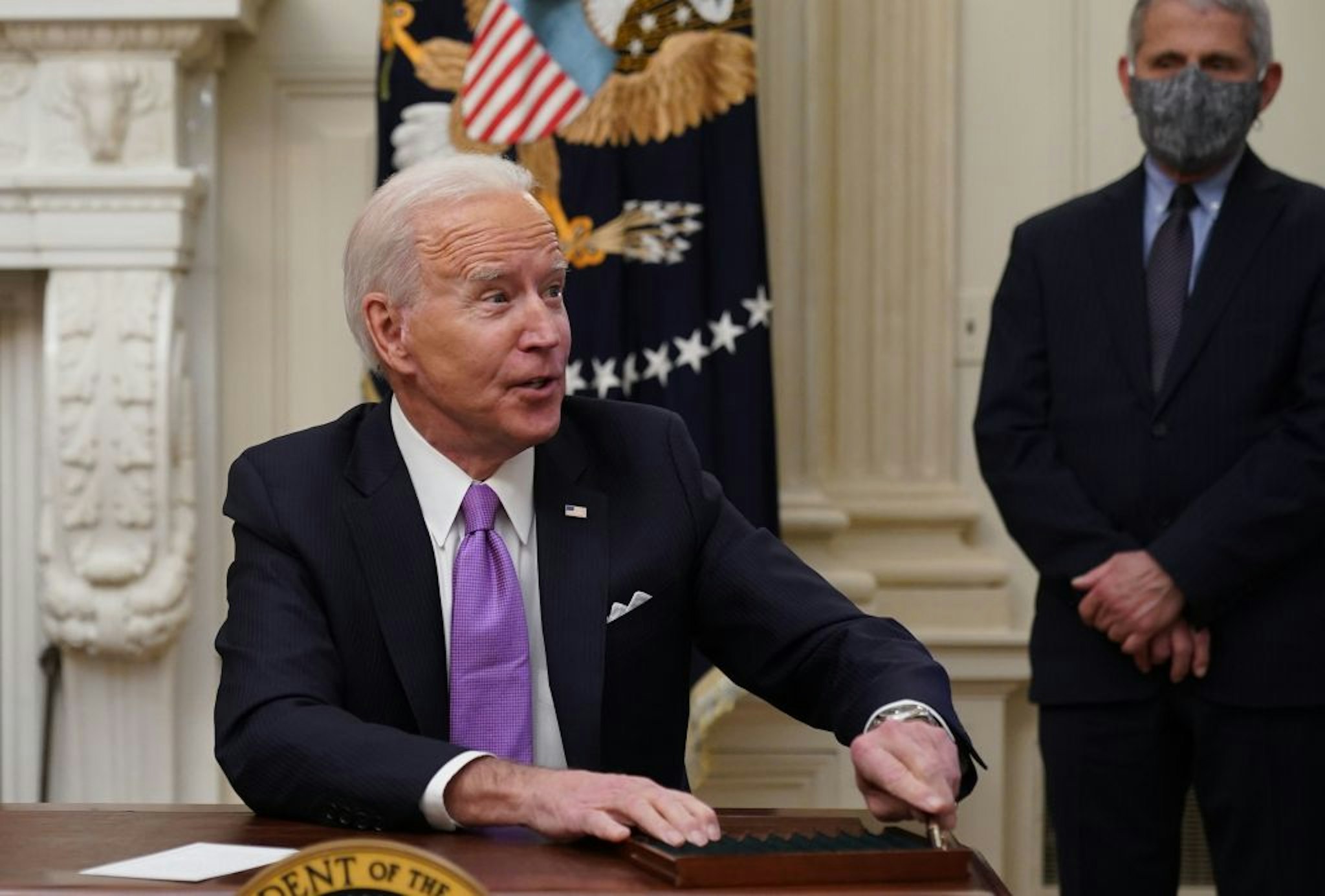 US President Joe Biden speaks to the press after signing executive orders as part of the Covid-19 response as Director of NIAID Anthony Fauci looks on in the State Dining Room of the White House in Washington, DC, on January 21, 2021. (Photo by MANDEL NGAN / AFP) (Photo by MANDEL NGAN/AFP via Getty Images)