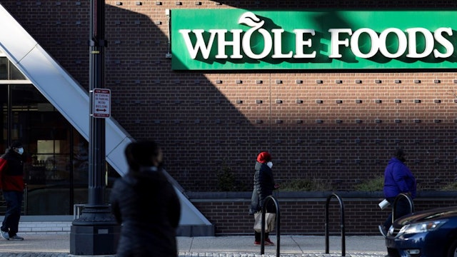 People walk past a Whole Foods market in Washington, D.C., the United States, March 5, 2021.