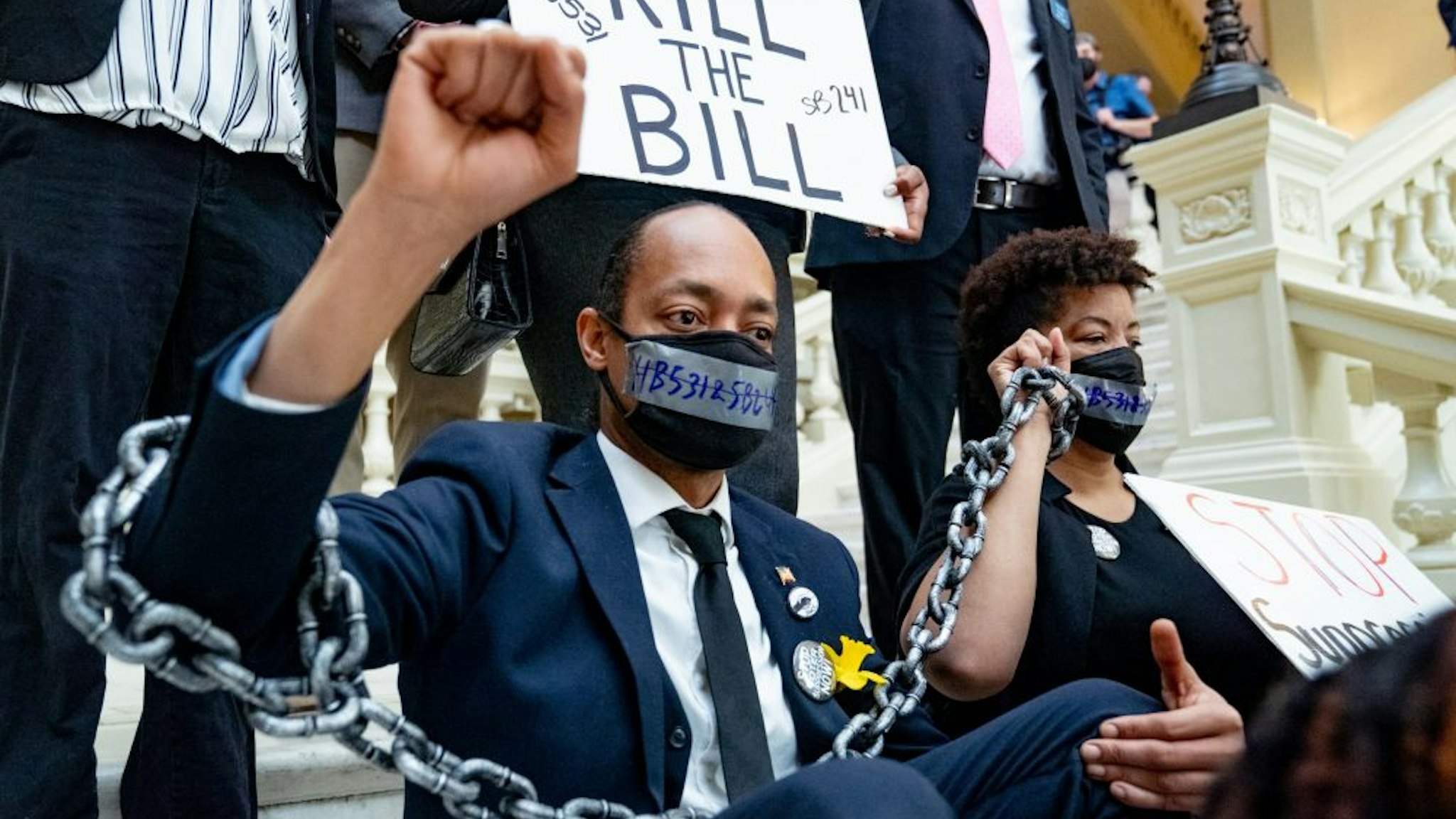 ATLANTA, GA - MARCH 08: Demonstrators wear chains while holding a sit-in inside of the Capitol building in opposition of House Bill 531 on March 8, 2021 in Atlanta, Georgia. HB531 will restrict early voting hours, remove drop boxes, and require the use of a government ID when voting by mail.