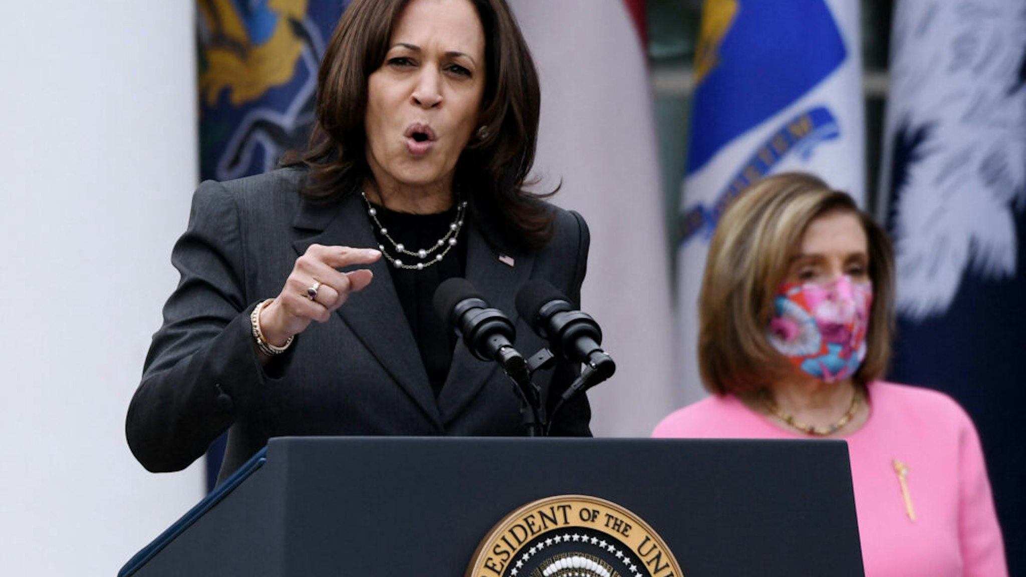 US Vice President Kamala Harris speaks as House Speaker Nancy Pelosi (D-CA) listens during an event on the American Rescue Plan in the Rose Garden of the White House in Washington, DC, on March 12, 2021.