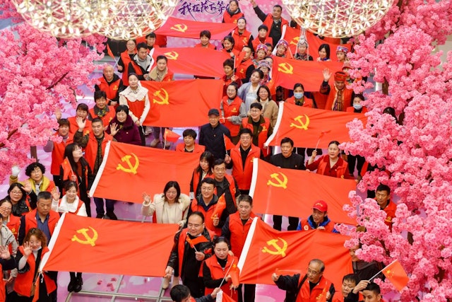 Members of the Communist Party of China (CPC) pose for a photo after sewing flags of the Communist Party of China on March 16, 2021 in Huzhou, Zhejiang Province of China.