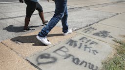 Ferguson Calm After Tense Anniversary Weekend FERGUSON, MO - AUGUST 12: Graffiti remains on the sidewalk along West Florrisant Avenue one year after the shooting of Michael Brown on August 12, 2015 in Ferguson, Missouri. Brown was shot and killed by a Ferguson police officer on August 9, 2014. (Photo by Scott Olson/Getty Images)