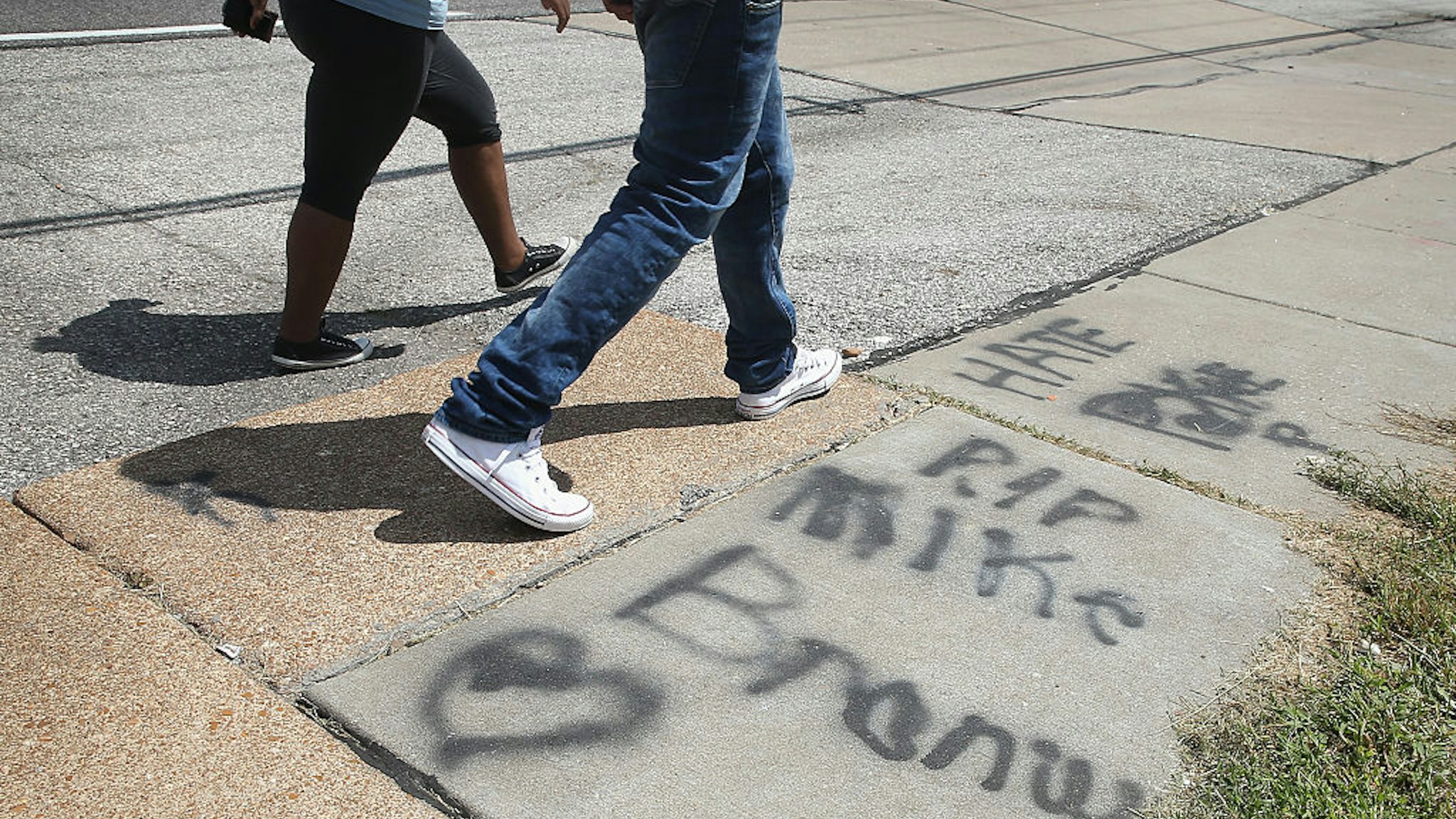 FERGUSON, MO - AUGUST 12: Graffiti remains on the sidewalk along West Florrisant Avenue one year after the shooting of Michael Brown on August 12, 2015 in Ferguson, Missouri. Brown was shot and killed by a Ferguson police officer on August 9, 2014. (Photo by Scott Olson/Getty Images)