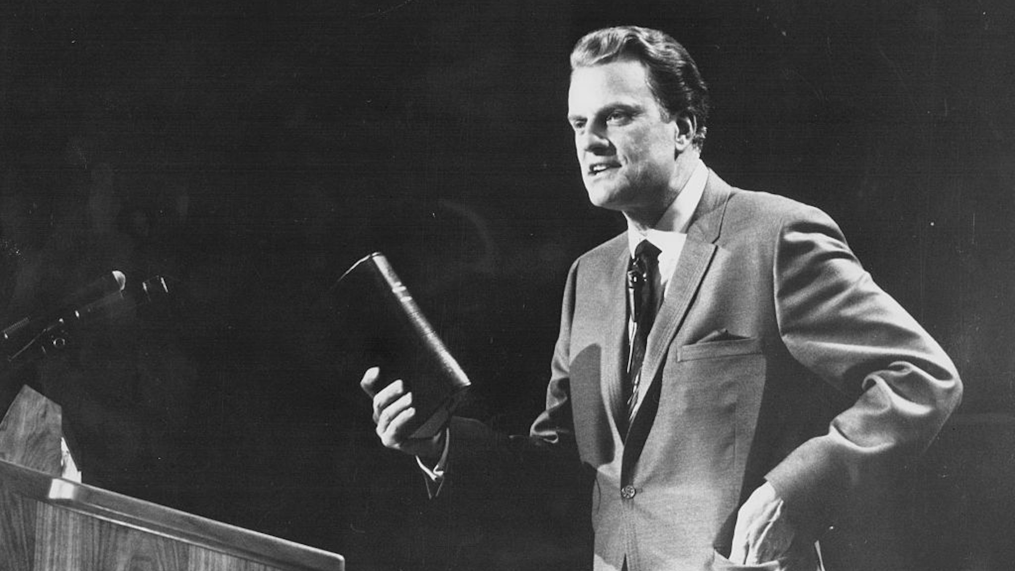 American evangelist Billy Graham, giving a speech on stage, circa 1970.