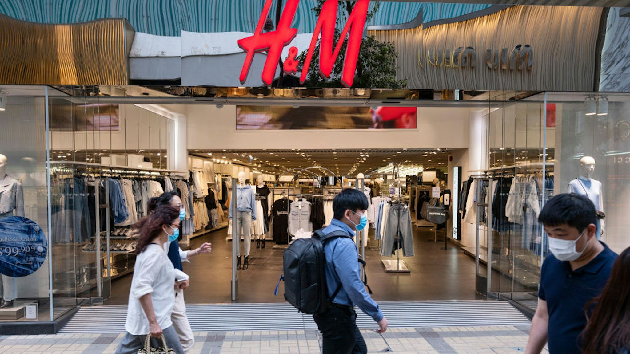 HONG KONG, CHINA - 2021/03/15: Pedestrians walk past the Swedish multinational clothing design retail company Hennes &amp; Mauritz, H&amp;M, store in Hong Kong. (Photo by Budrul Chukrut/SOPA Images/LightRocket via Getty Images)