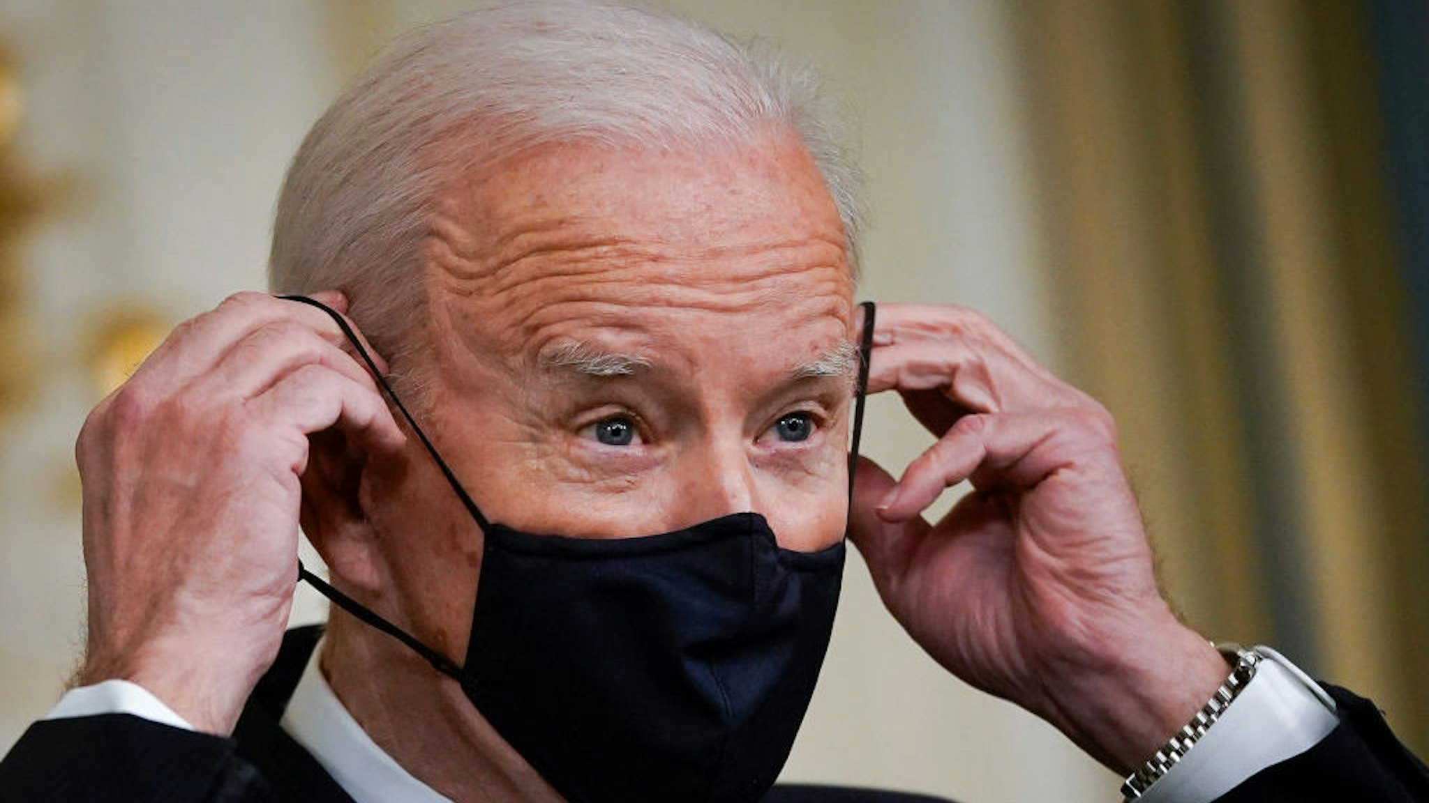 WASHINGTON, DC - MARCH 15: U.S. President Joe Biden puts on a face covering as he concludes his remarks in the State Dining Room of the White House on March 15, 2021 in Washington, DC. The administration announced on Monday that Gene Sperling, a former top economic official in the last two Democratic presidential administrations, will oversee the rollout of the $1.9 trillion coronavirus stimulus package that Biden signed into law last week. (Photo by Drew Angerer/Getty Images)