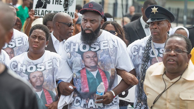 FERGUSON, MO - AUGUST 09: Michael Brown Sr. (C) leads a march from the location where his son Michael Brown Jr. was shot and killed following a memorial service marking the anniversary his death on August 9, 2015 in Ferguson, Missouri.