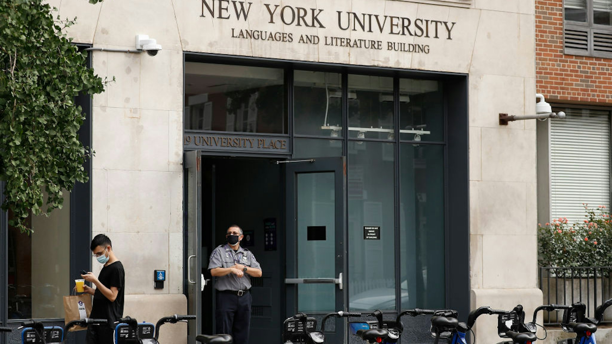 NEW YORK, NEW YORK- SEPTEMBER 17: A security guard stand outside a New York University building during Phase 4 of re-opening following restrictions imposed to slow the spread of coronavirus on September 17, 2020 in New York City . The fourth phase allows outdoor arts and entertainment, sporting events without fans and media production.