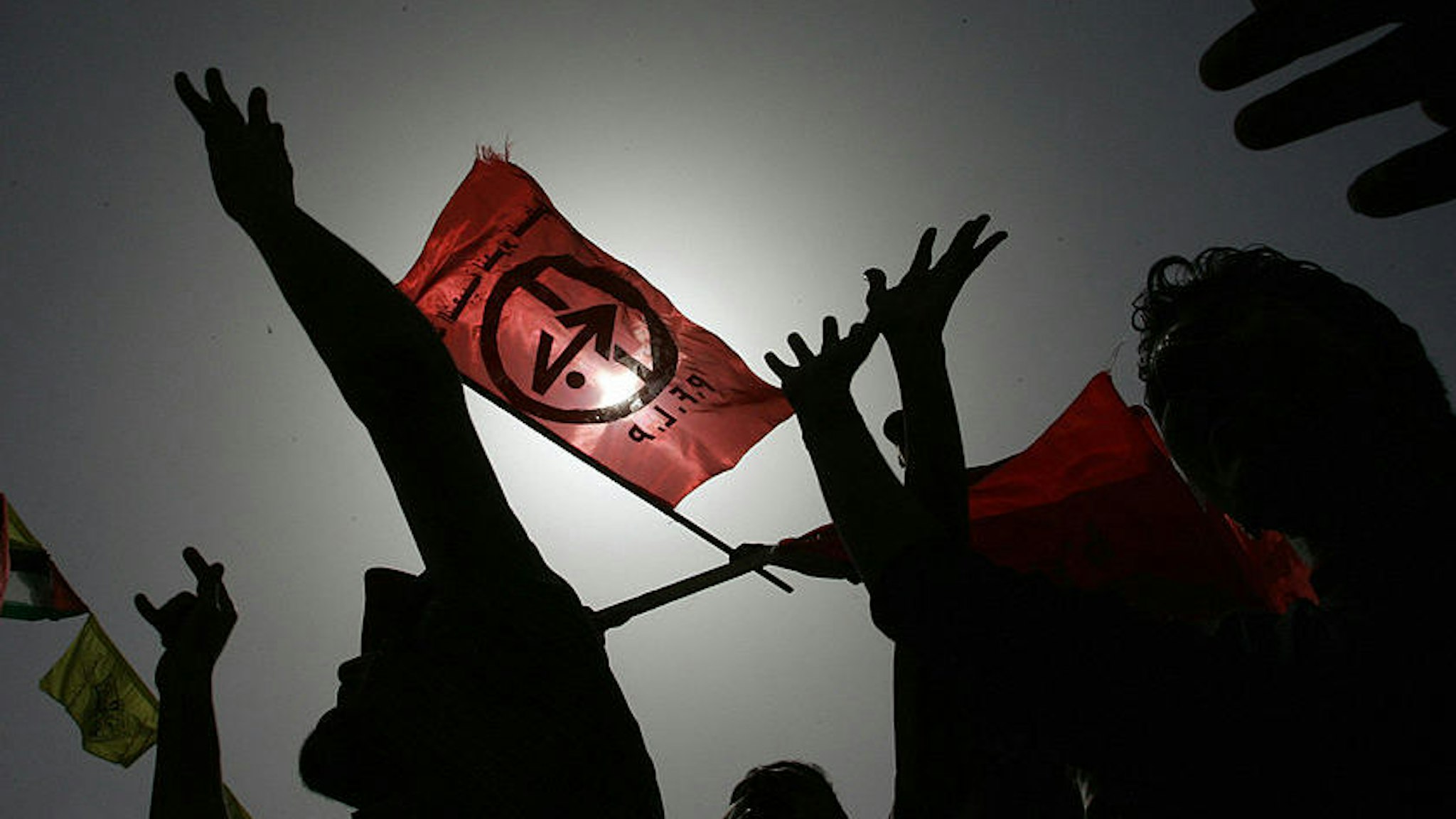 Supporters of the Popular Front for the Liberation Palestine hold up the PFLP red flag as they demonstrate at the Palestinian parliament in Gaza City 14 March 2006. Protests broke out across the West Bank and Gaza Strip as Israeli troops stormed a prison compound in the West Bank town of Jericho in a vast operation to arrest jailed militant Ahmed Saadat, the leader of the leftist Popular Front for the Liberation of Palestine and his three comrades held over the assassination in 2001of far-right Israeli tourism minister Rehavam Zeevi. A Palestinian security guard was killed and 18 others wounded in the Israeli attack. AFP PHOTO/MOHAMMED ABED (Photo credit should read MOHAMMED ABED/AFP via Getty Images)