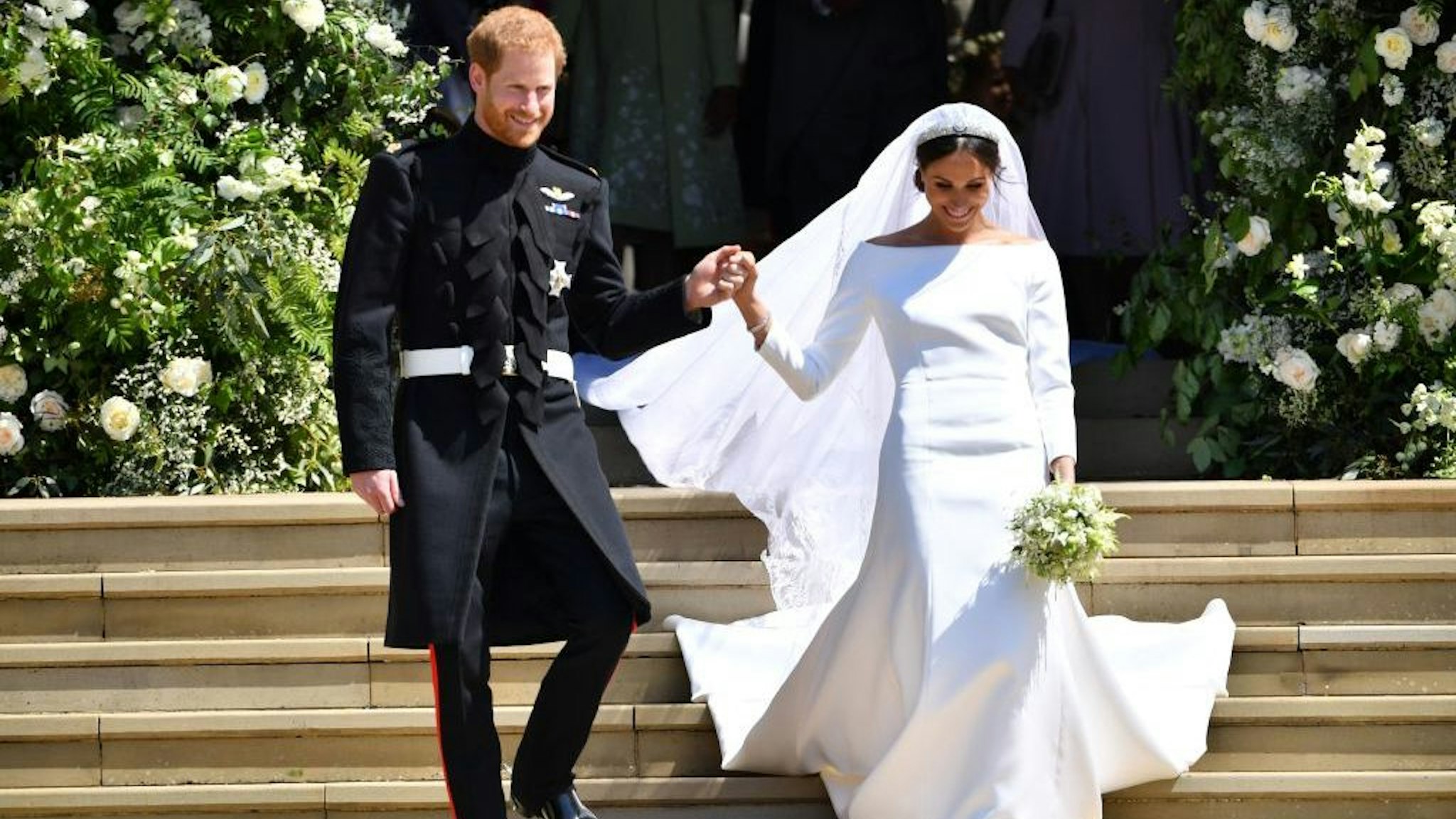 In this file photo taken on May 19, 2018, Britain's Prince Harry, Duke of Sussex and his wife Meghan, Duchess of Sussex emerge from the West Door of St George's Chapel, Windsor Castle, in Windsor, after their wedding ceremony. (Photo by BEN STANSALL/AFP via Getty Images)
