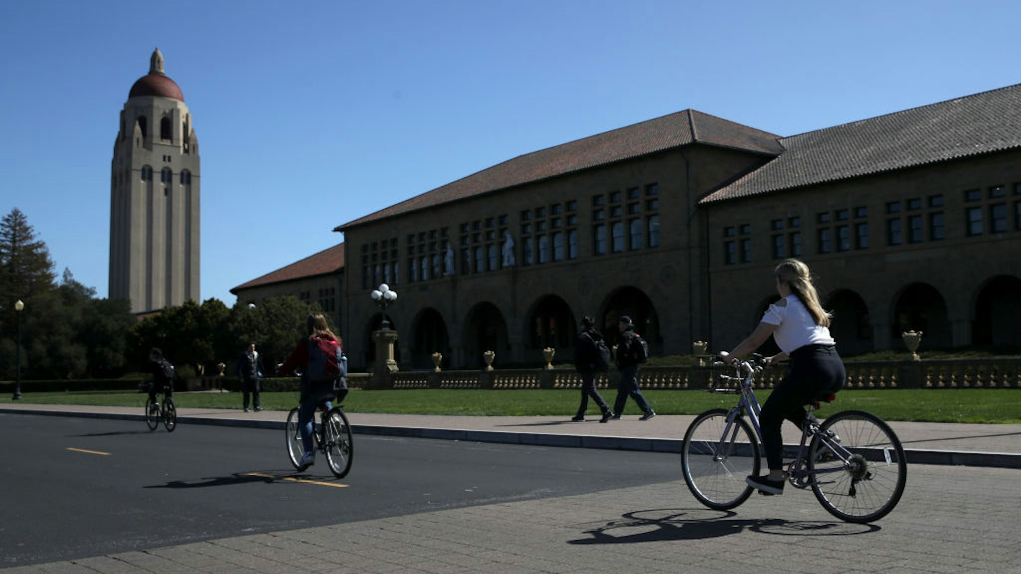 STANFORD, CA - MARCH 12: Cyclists ride by Hoover Tower on the Stanford University campus on March 12, 2019 in Stanford, California. More than 40 people, including actresses Lori Loughlin and Felicity Huffman, have been charged in a widespread elite college admission bribery scheme. Parents, ACT and SAT administrators and coaches at universities including Stanford, Georgetown, Yale, and the University of Southern California have been charged.
