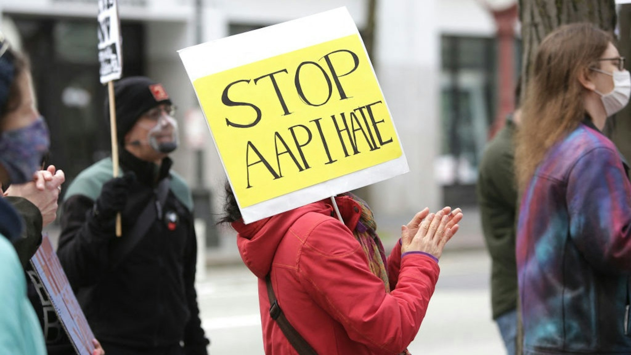 A demonstrator holds a sign calling for a stop to hate against Asian Americans and Pacific Islanders (AAPI) during a national day of action against anti-Asian violence in Seattle, Washington on March 27, 2021.
