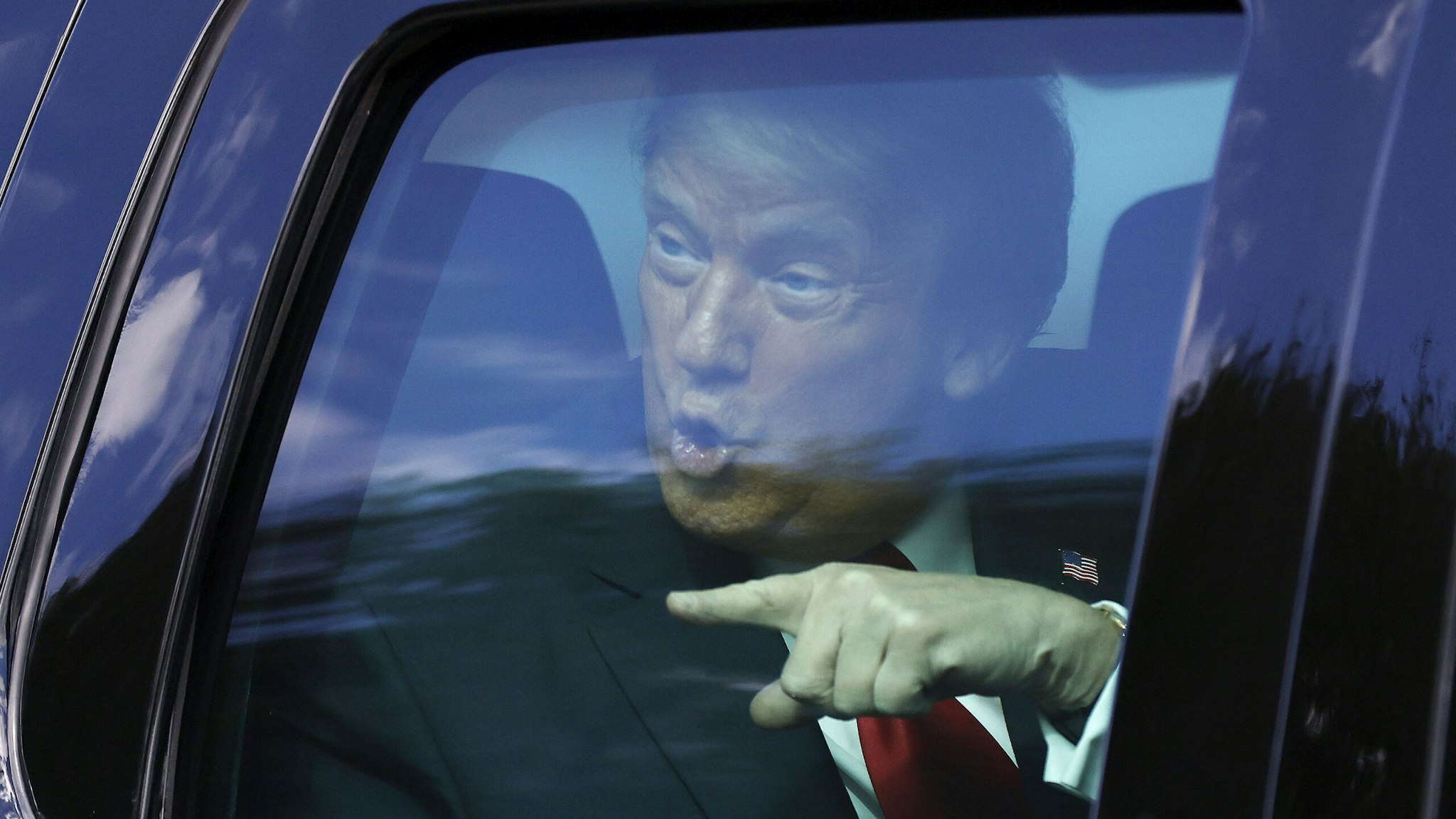 WEST PALM BEACH, FLORIDA - JANUARY 20: Outgoing US President Donald Trump waves to supporters lined along on the route to his Mar-a-Lago estate on January 20, 2021 in West Palm Beach, Florida. Trump, the first president in more than 150 years to refuse to attend his successor's inauguration, is expected to spend the final minutes of his presidency at his Mar-a-Lago estate in Florida.