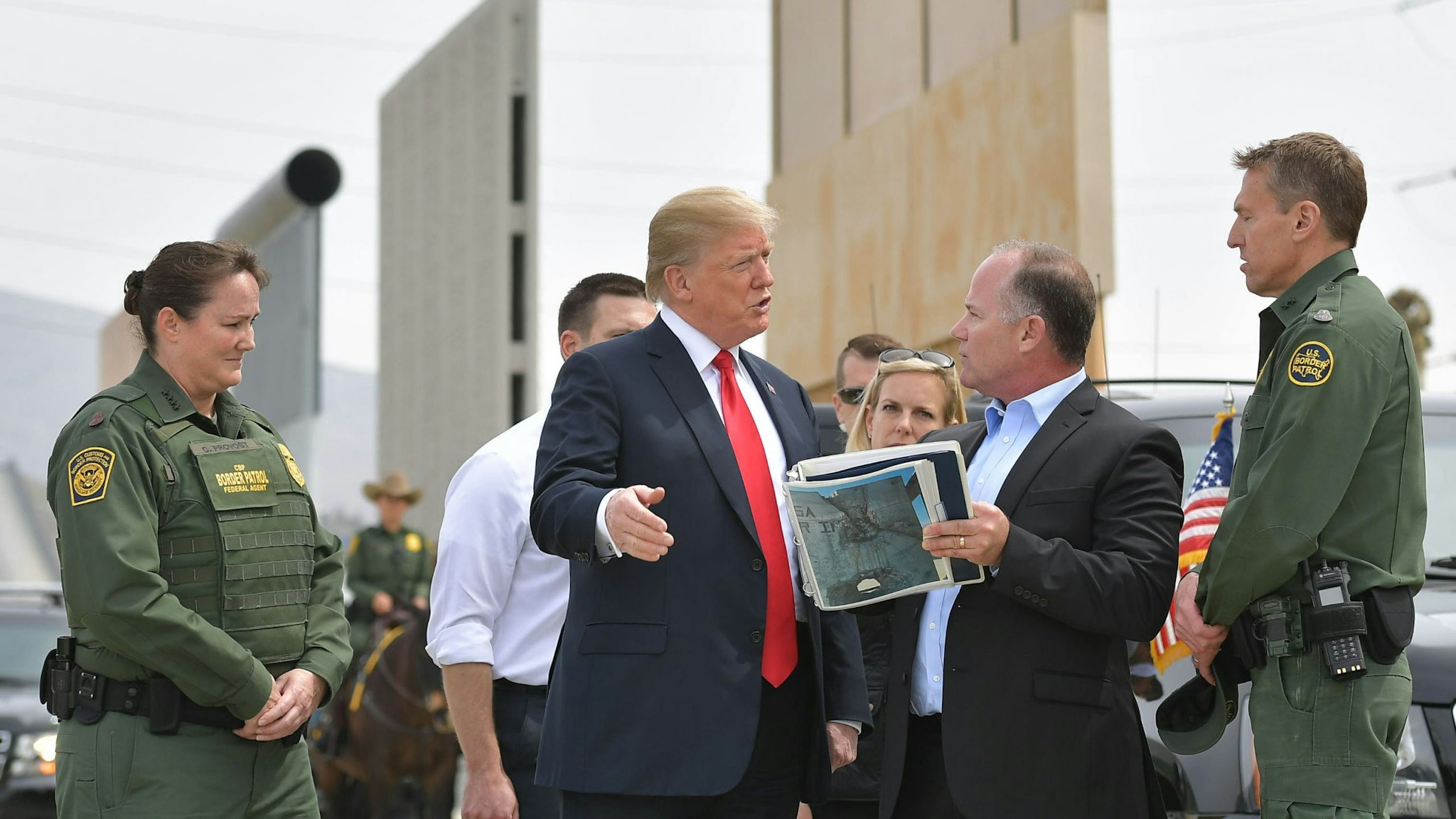US President Donald Trump (C) is shown border wall prototypes in San Diego, California on March 13, 2018.