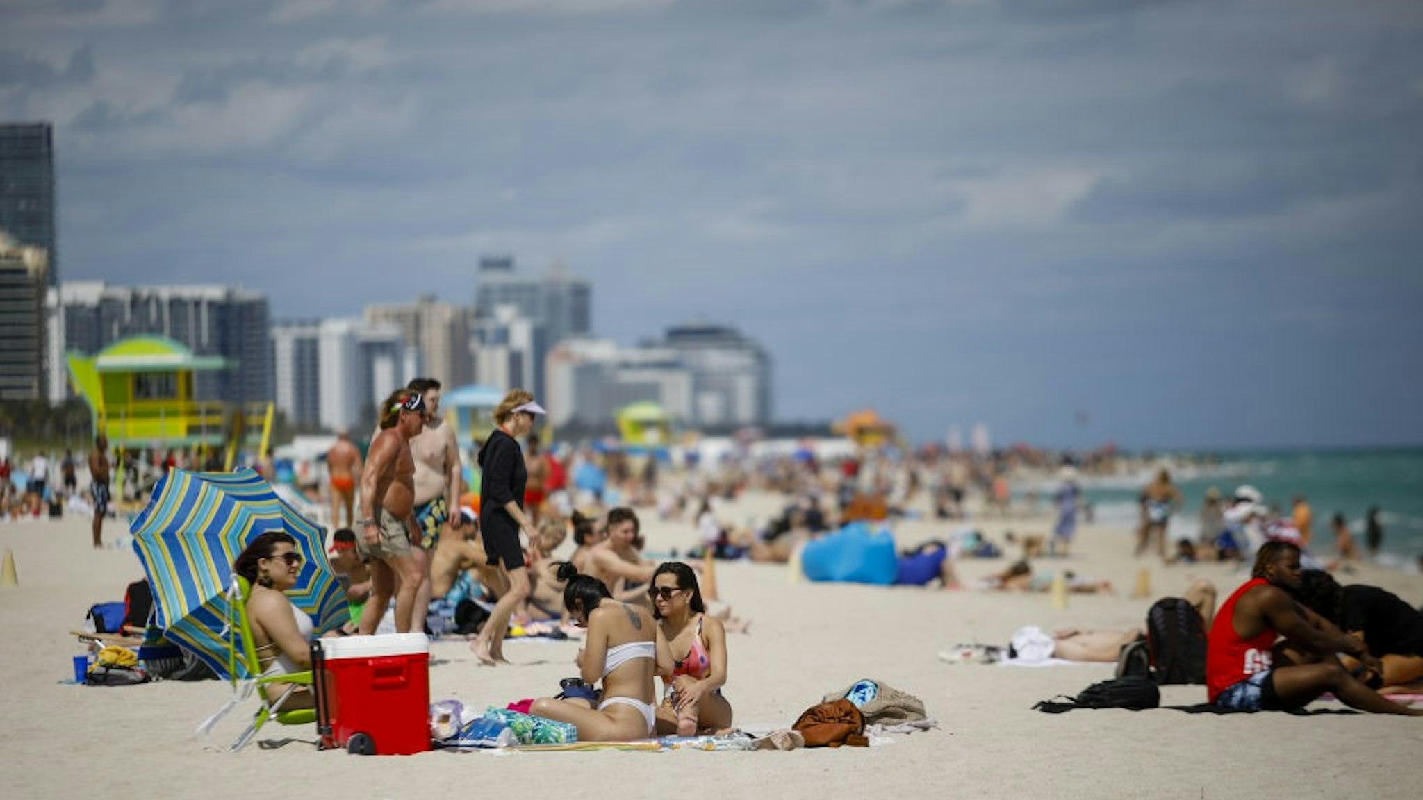 People gather on a beach in Miami, Florida, U.S., on Saturday, March 5, 2021. Even with some colleges canceling their mid-semester breaks, students from more than 200 schools are expected to visit Miami Beach during spring break, which runs from late February to mid-April. Photographer: