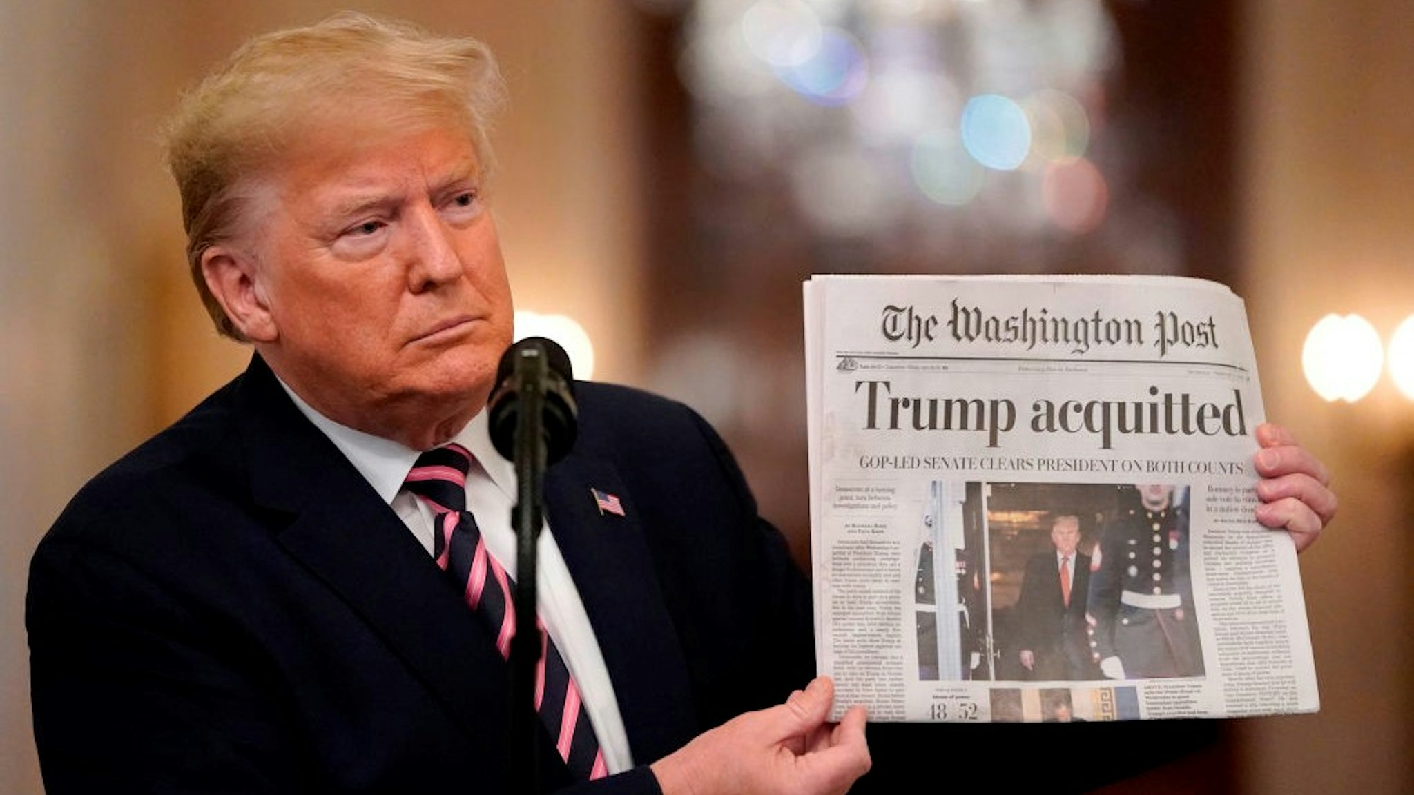 WASHINGTON, DC - FEBRUARY 06: U.S. President Donald Trump holds a copy of The Washington Post as he speaks in the East Room of the White House one day after the U.S. Senate acquitted on two articles of impeachment, ion February 6, 2020 in Washington, DC. After five months of congressional hearings and investigations about President Trump’s dealings with Ukraine, the U.S. Senate formally acquitted the president on Wednesday of charges that he abused his power and obstructed Congress. (Photo by
