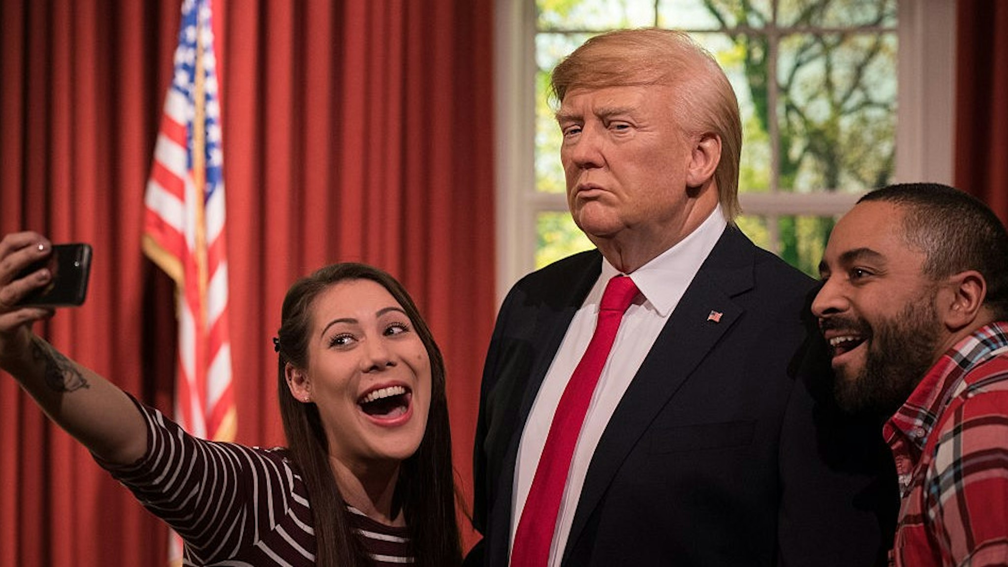 LONDON, ENGLAND - JANUARY 18: Helen Smith and Jason Holliday pose for photographs taking a selfie as Madame Tussauds unveils a wax figure of President-Elect Donald J. Trump ahead of the inauguration on Friday at Madame Tussauds London on January 18, 2017 in London, England. The figure of Donald Trump is placed amongst the setting of the Oval Office. (Photo by