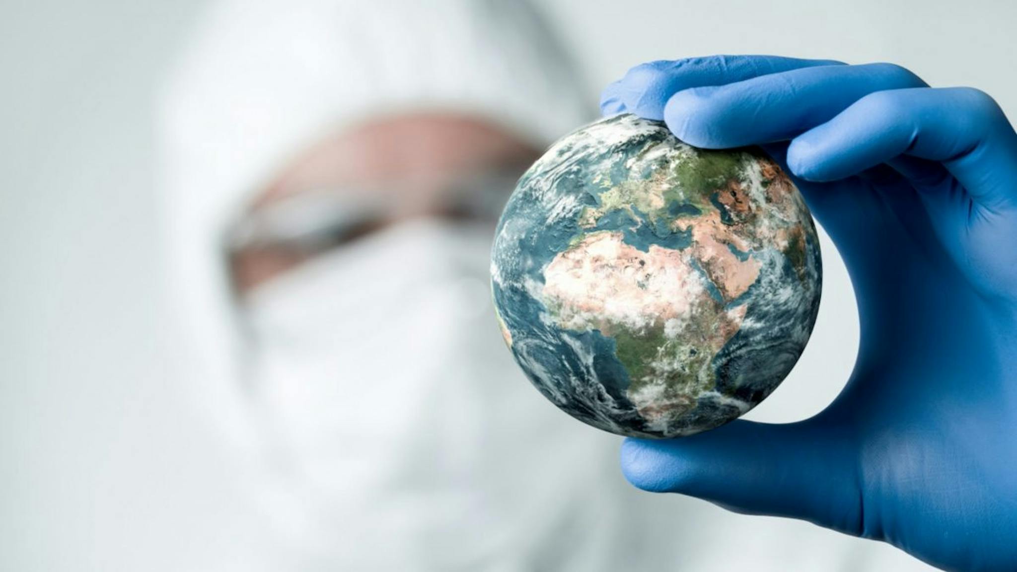 Earth Pandemic concept, close up of scientist holdnig and analyzing planet earth.