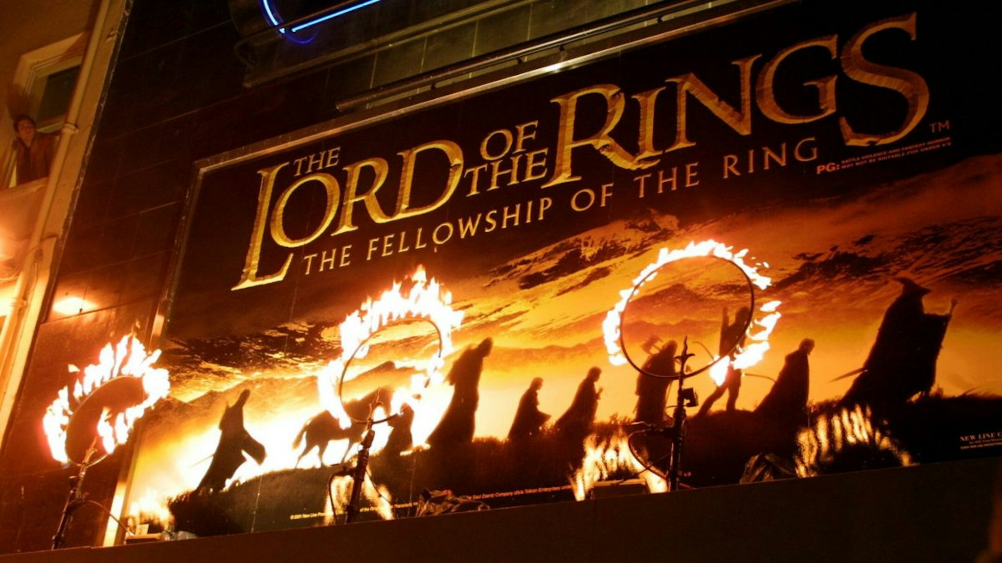 Rings of fire burn near the movie poster for the film "The Lord of the Rings: The Fellowship of the Ring." The stars of the film attended the premiere in London.
